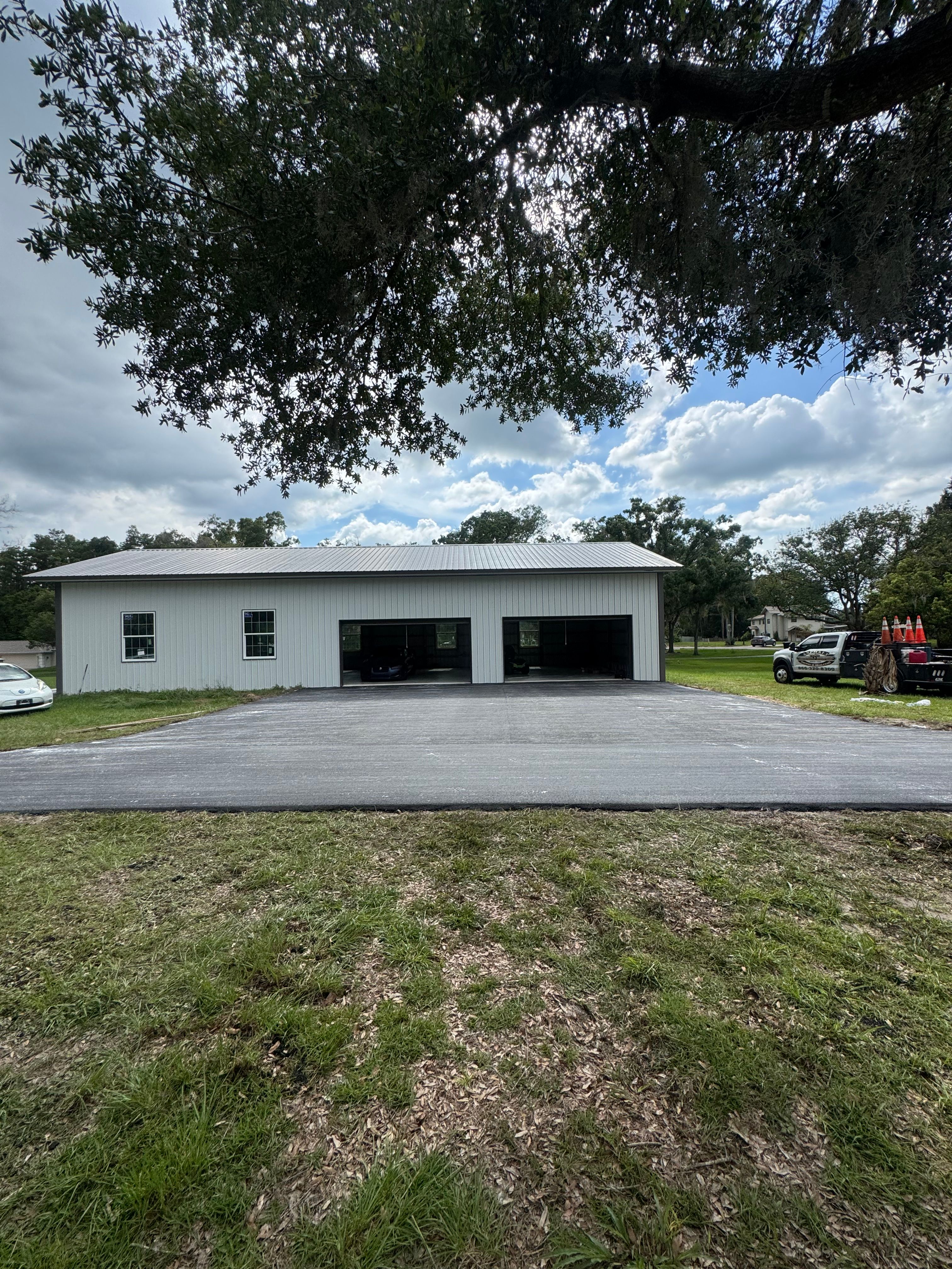 Completed asphalt driveway and parking apron at an outbuilding