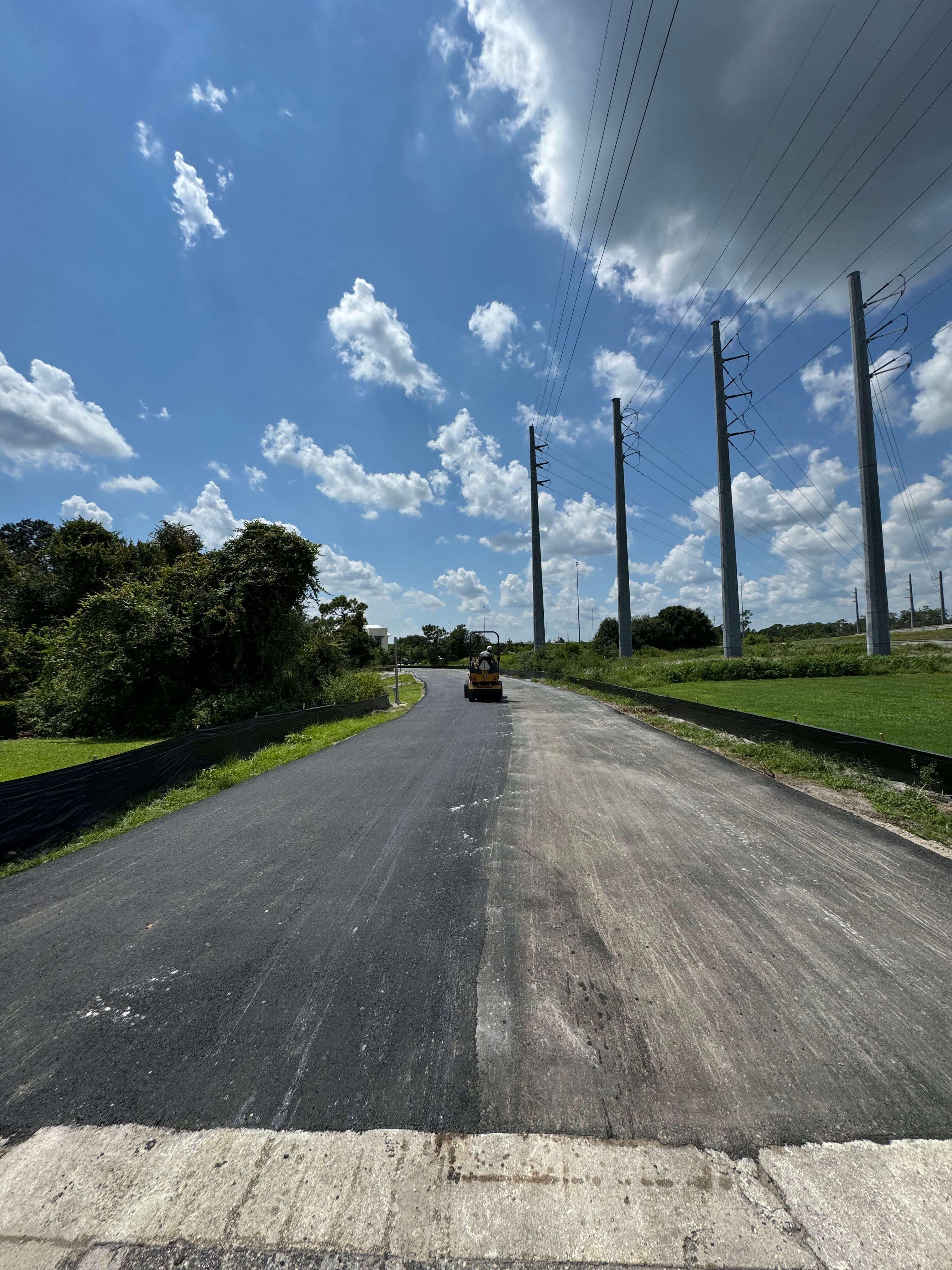 Asphalt placement in progress on a private road
