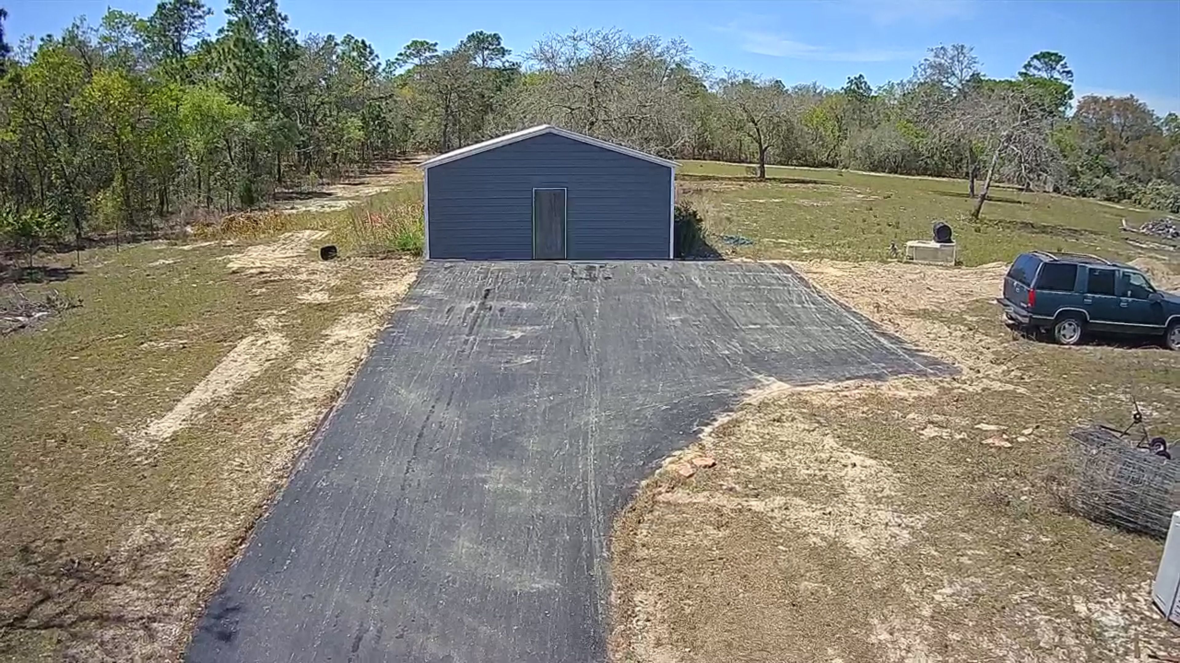 Aerial view of a completed asphalt driveway and parking apron