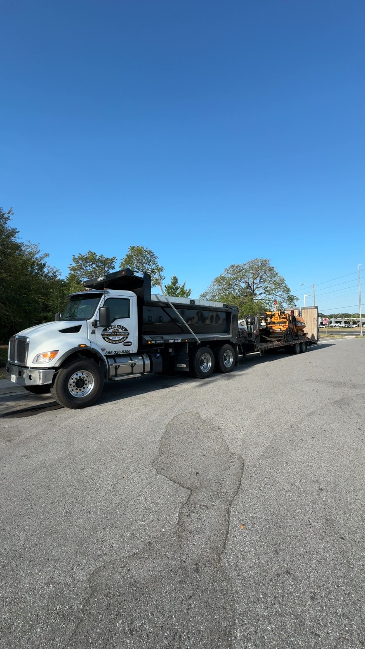 Asphalt maintenance trucks working in a commercial parking lot