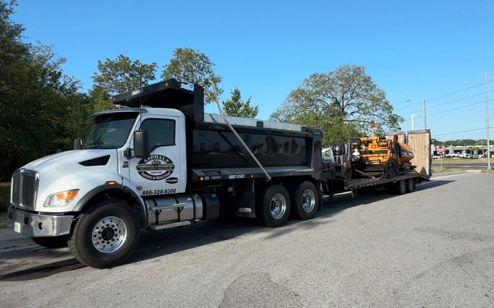 Asphalt maintenance trucks working in a commercial parking lot