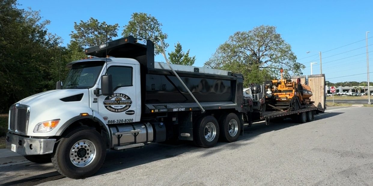 Asphalt maintenance trucks working in a commercial parking lot