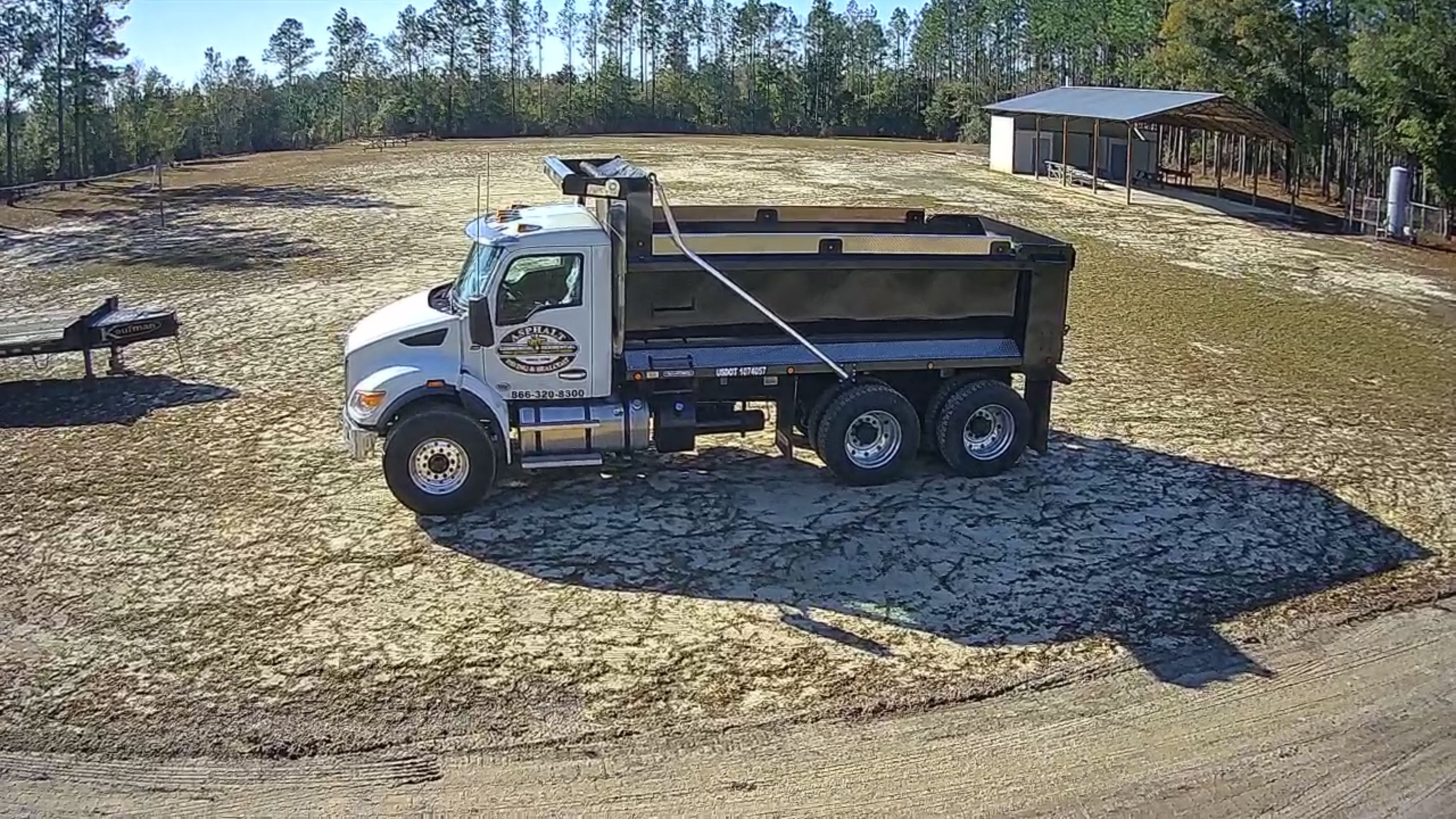 Dump truck delivering material during private driveway preparation