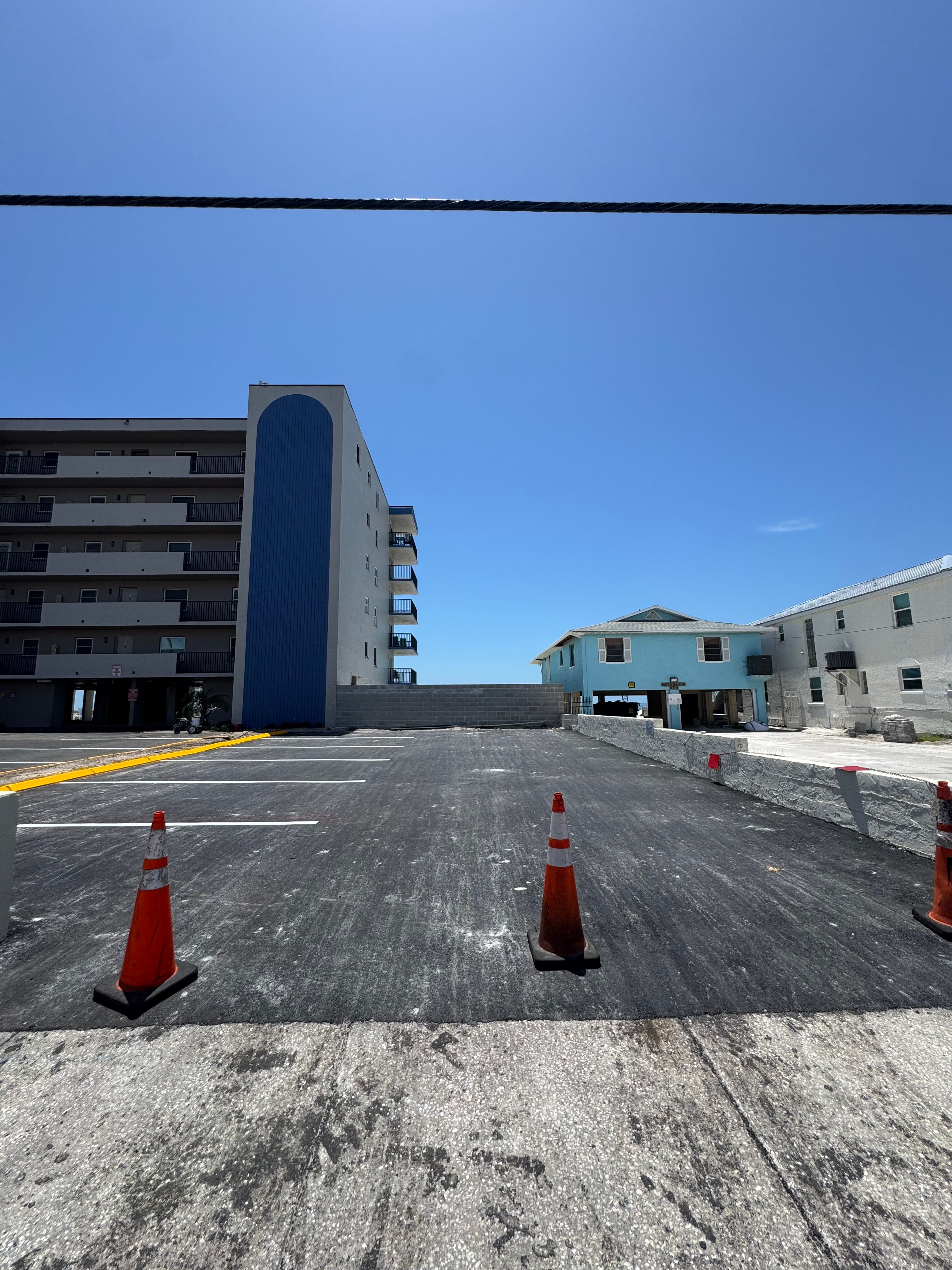 Parking-lot paving work beside a multi-story property