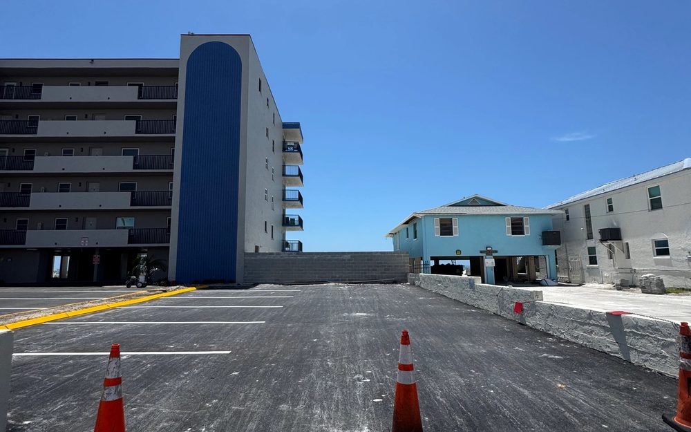 Parking-lot paving work beside a multi-story property