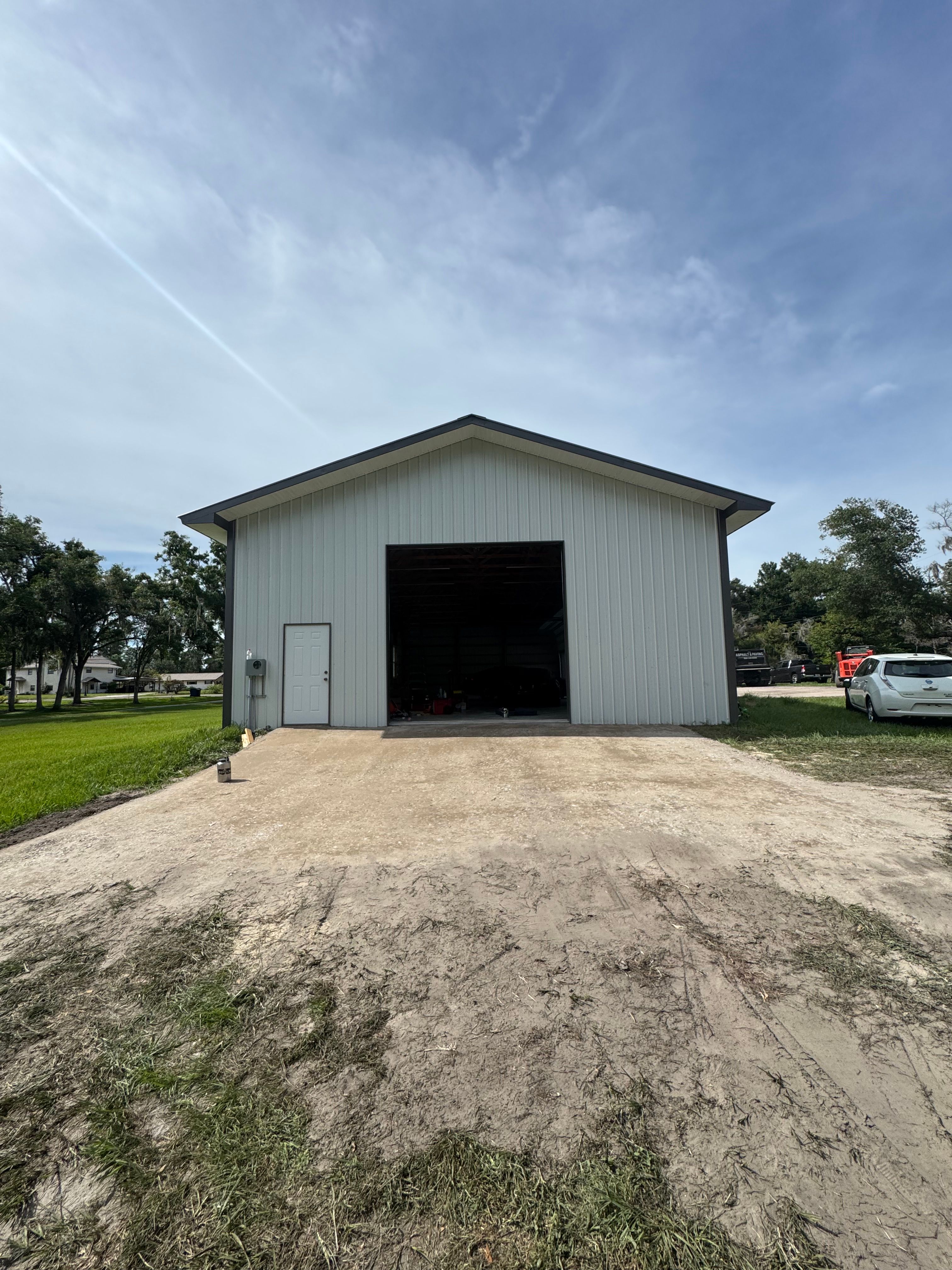 Unpaved driveway and apron before asphalt work at an outbuilding