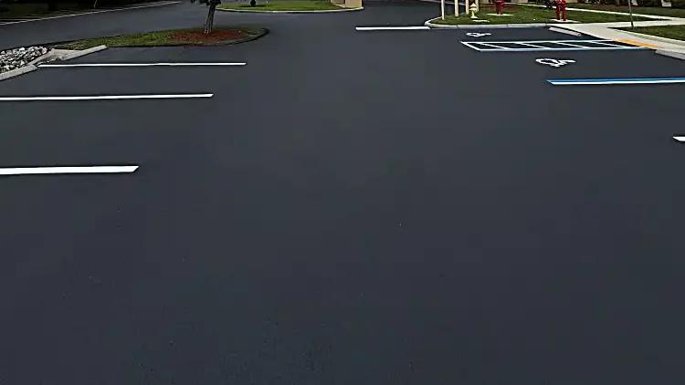 Commercial parking lot with dark sealcoat and fresh white parking-space markings