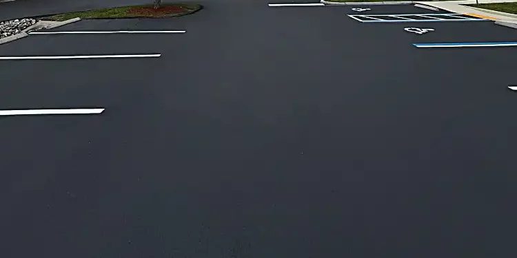Commercial parking lot with dark sealcoat and fresh white parking-space markings