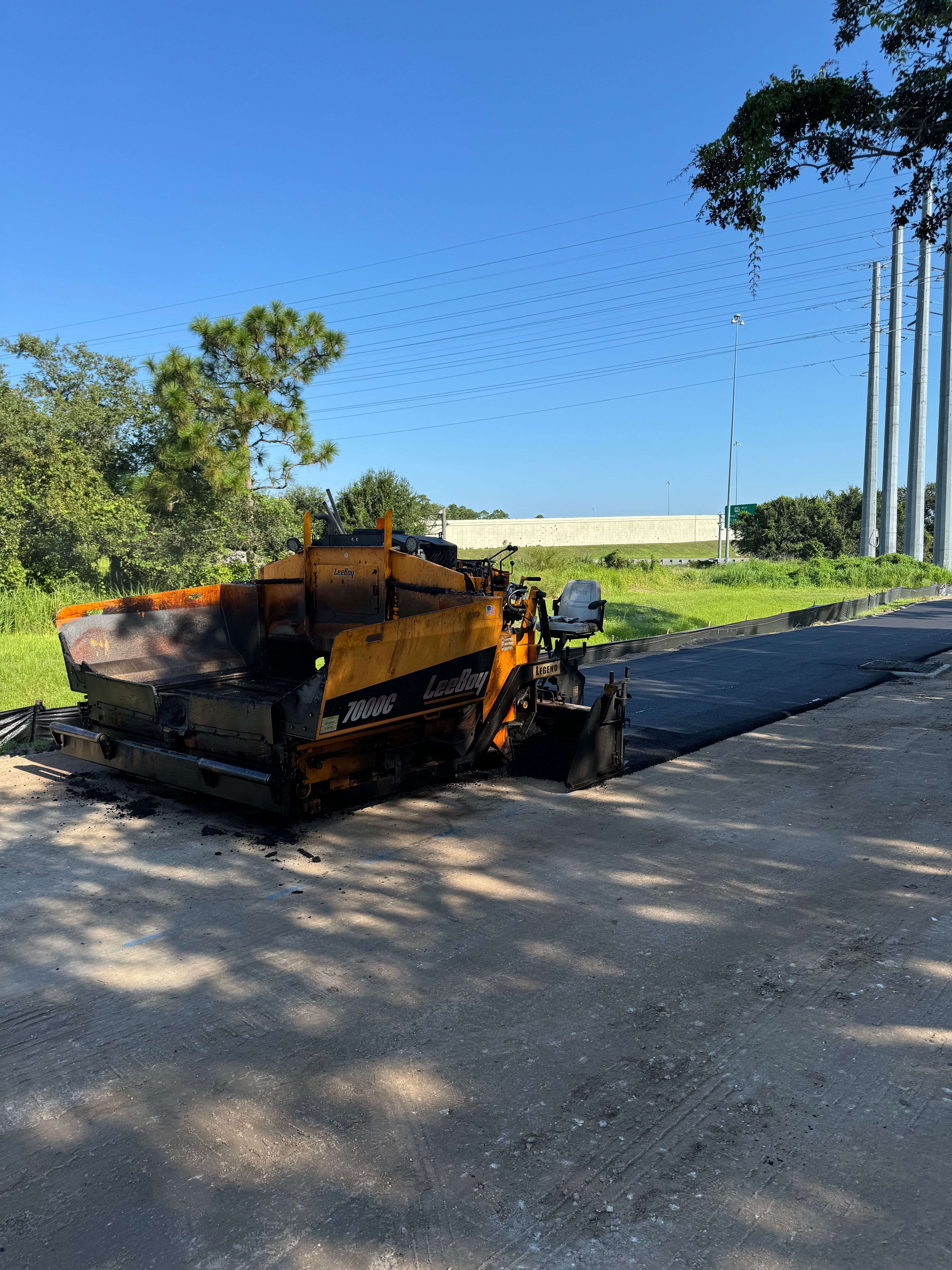 Paving equipment placing asphalt on a prepared road base