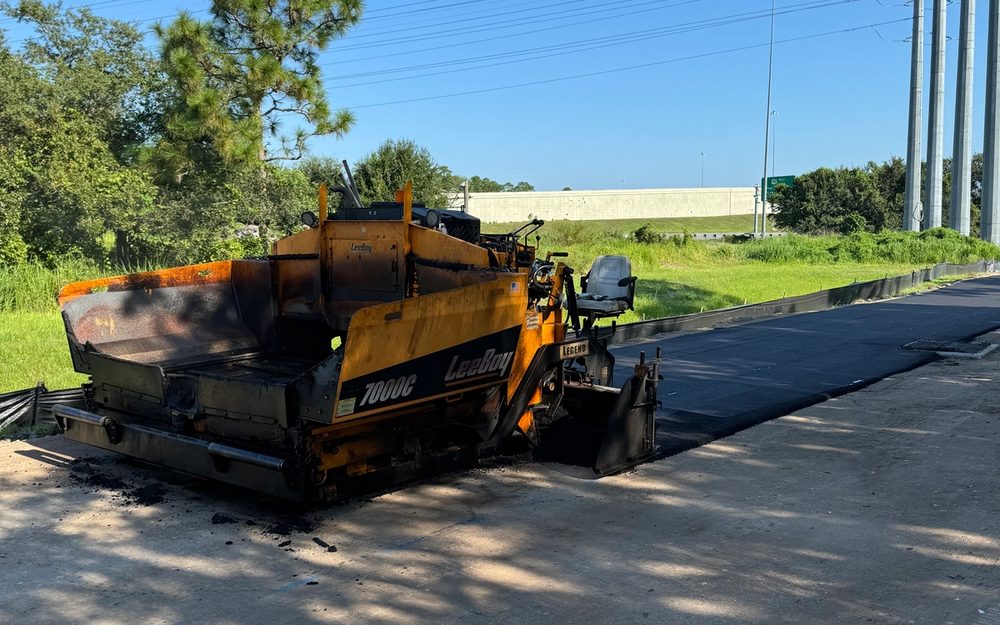Paving equipment placing asphalt on a prepared road base