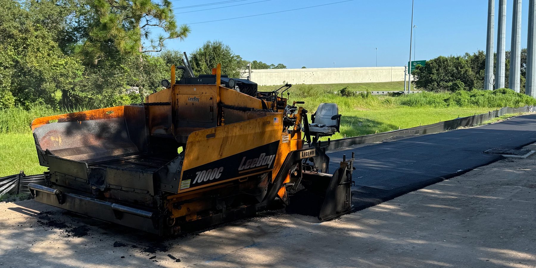 Paving equipment placing asphalt on a prepared road base