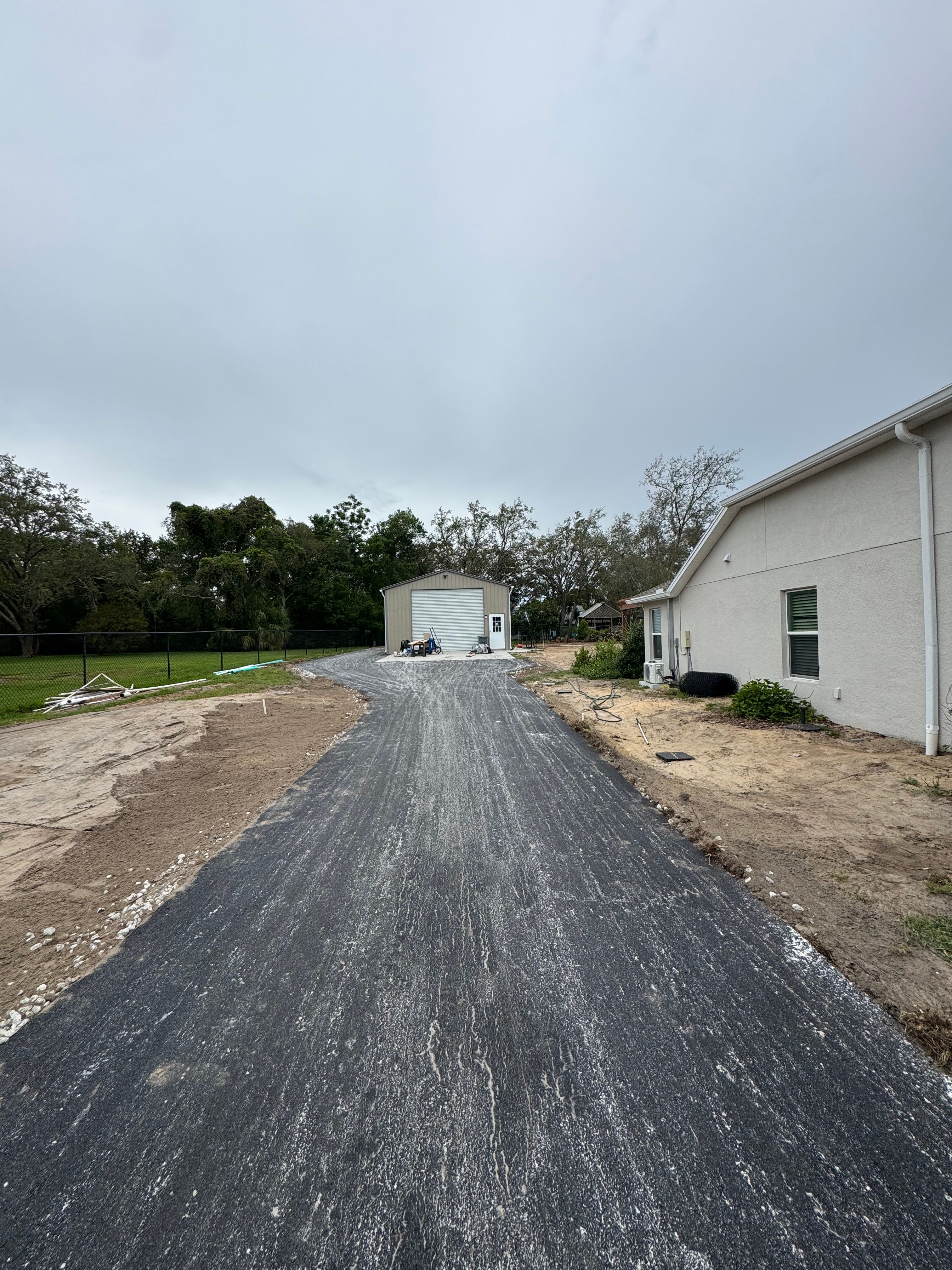 Prepared aggregate driveway base beside a residential garage
