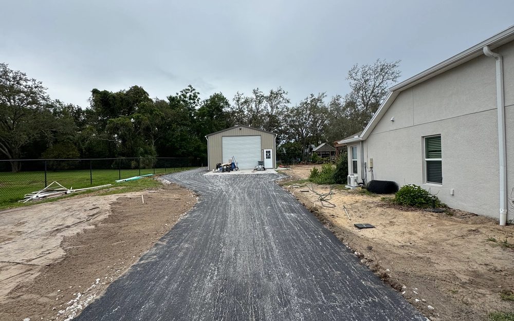 Prepared aggregate driveway base beside a residential garage