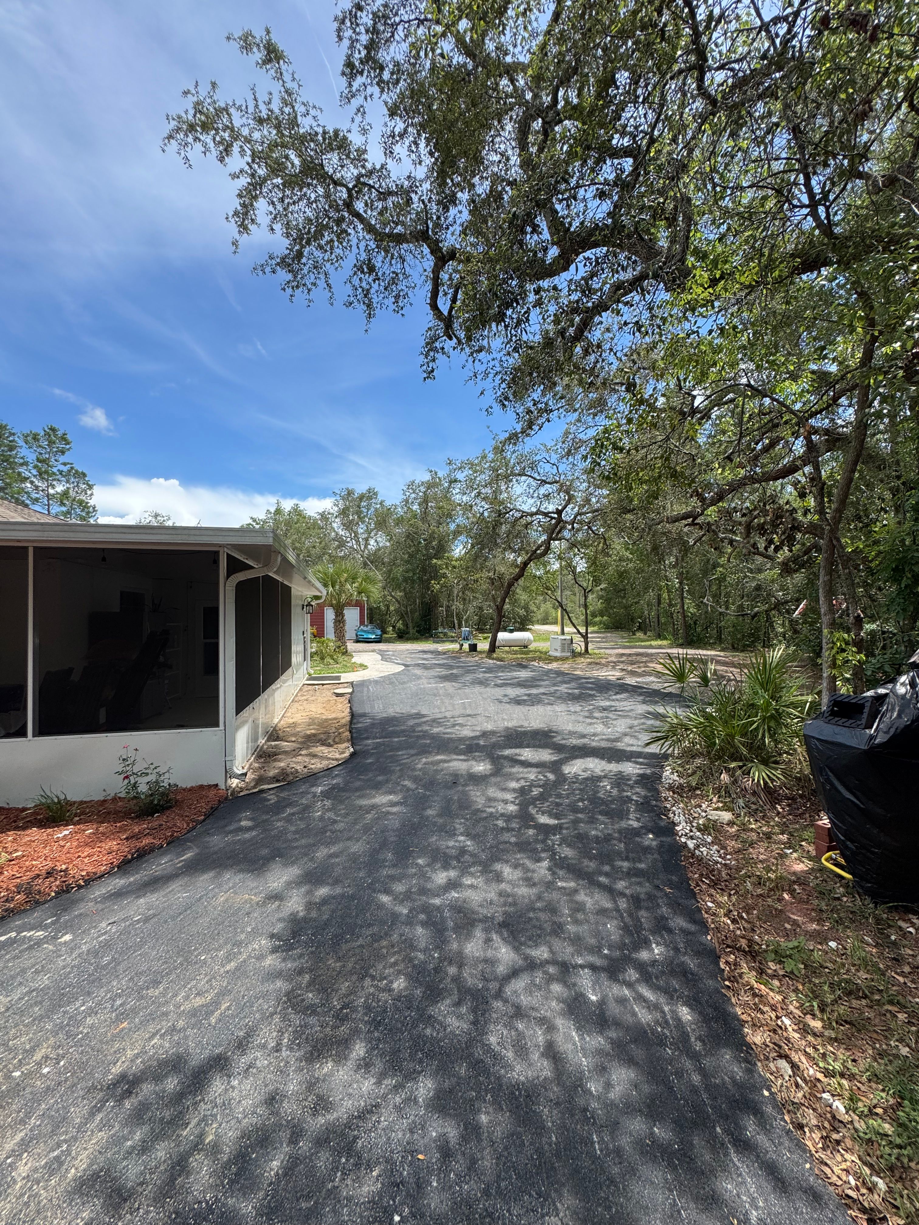 Finished asphalt driveway beside a residential home