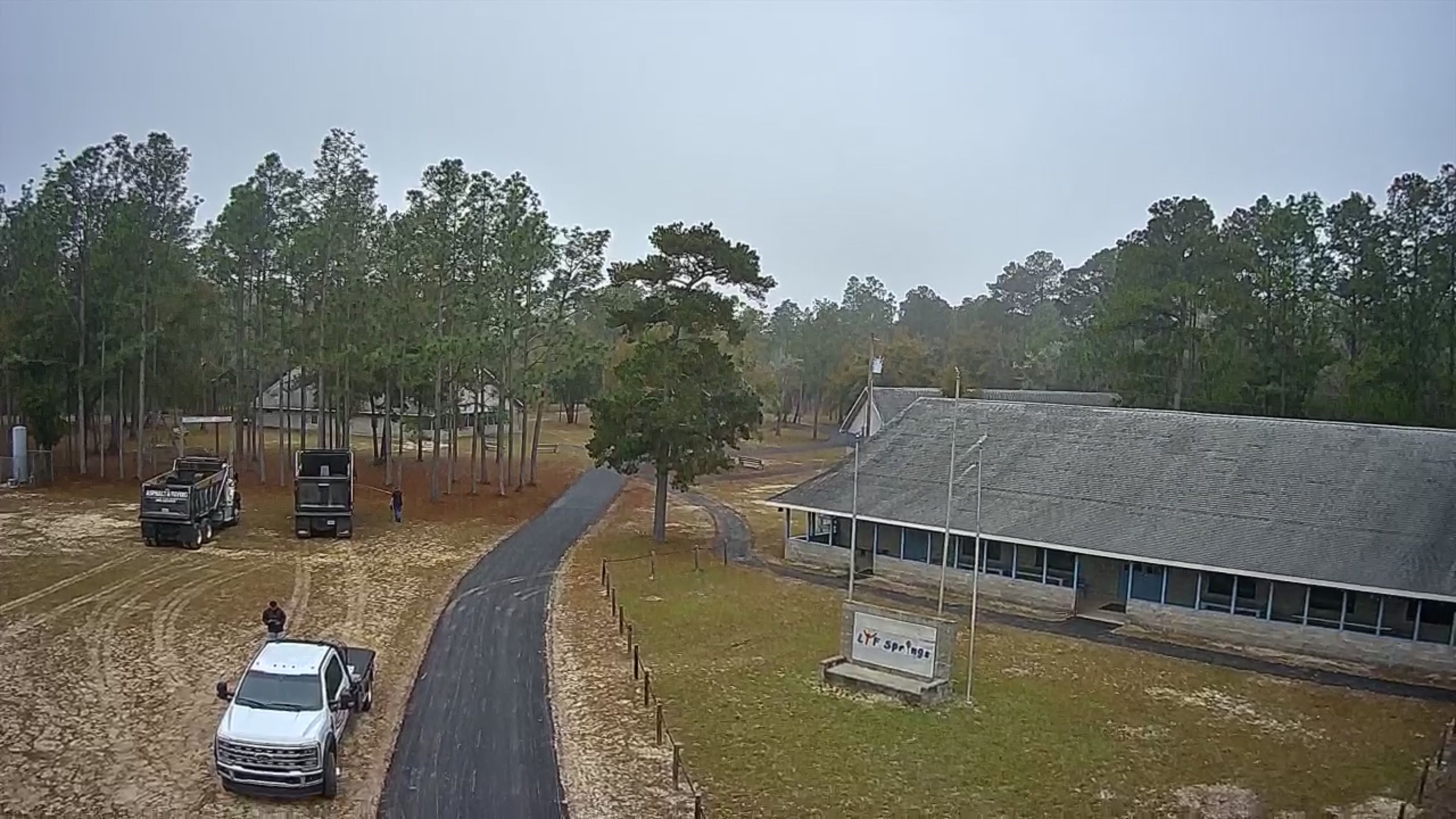 Aerial overview of completed asphalt drives around a rural property