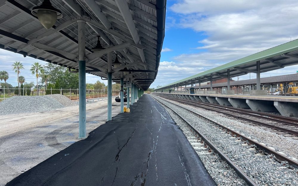 Asphalt paving equipment working beside a covered platform