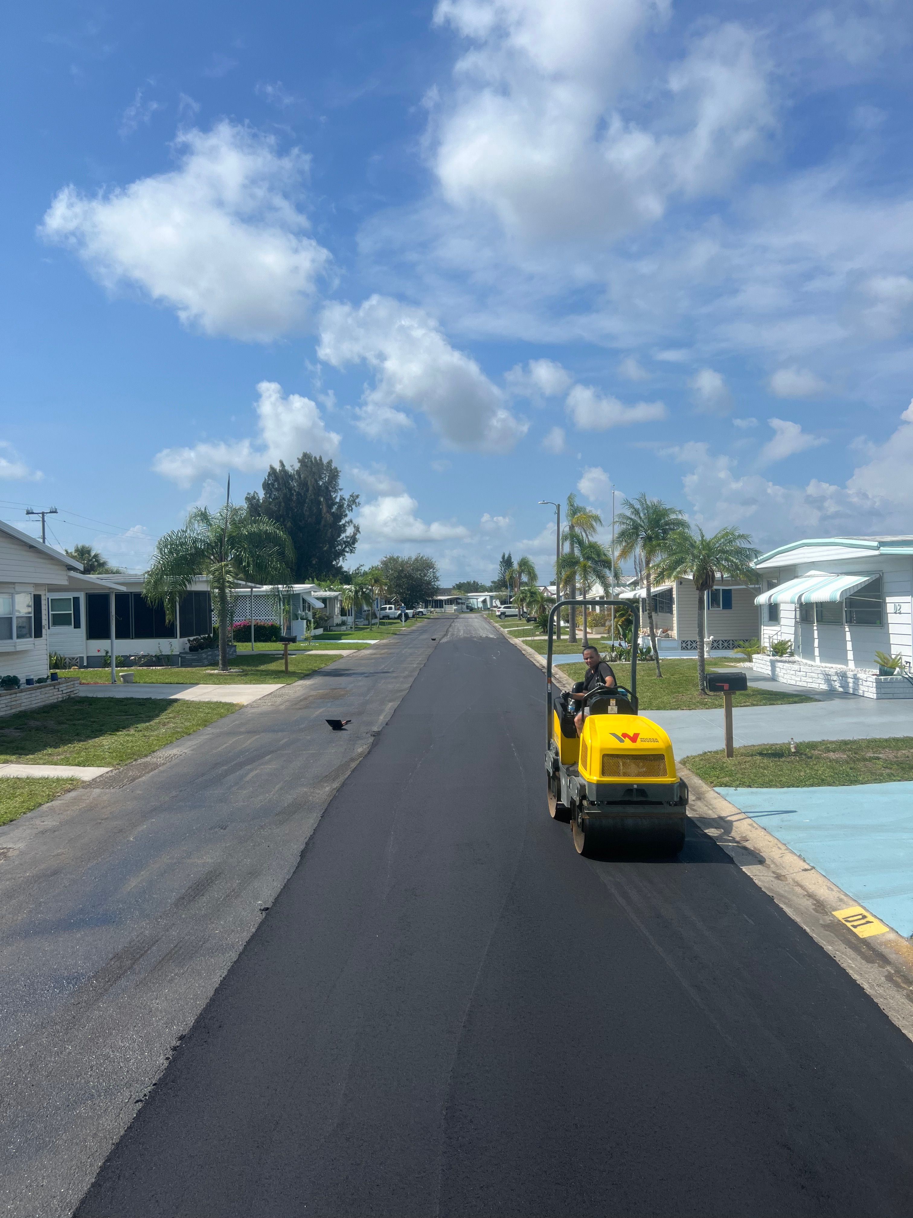 Roller compacting new asphalt on a residential community street