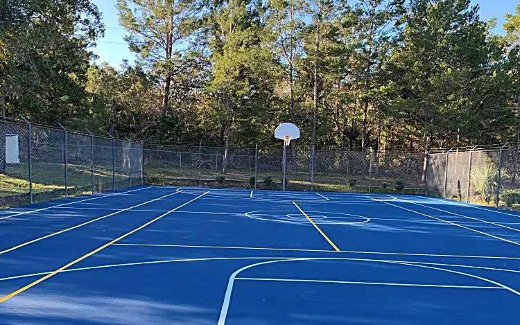 Resurfaced blue basketball court with fresh white and yellow game lines