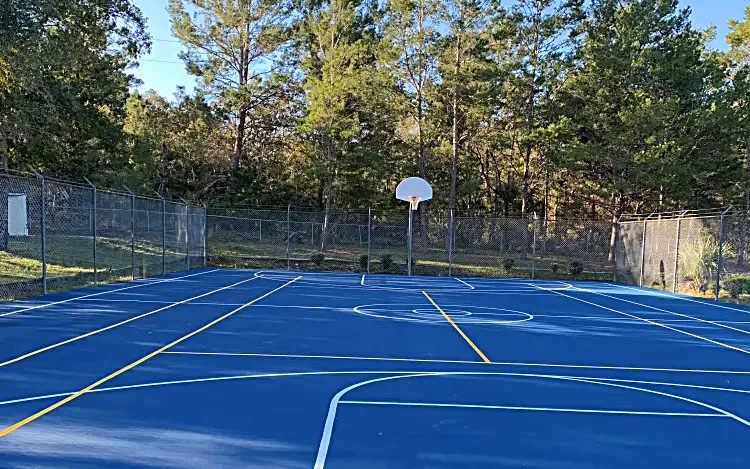 Resurfaced blue basketball court with fresh white and yellow game lines