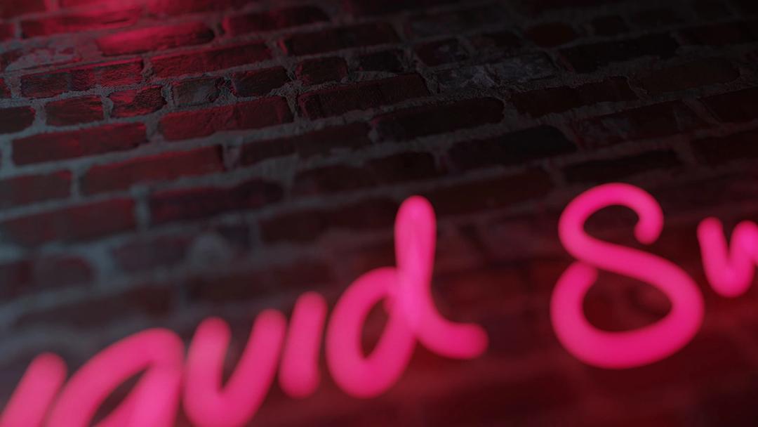 Neon sign “Liquid Swords” on a brick wall.