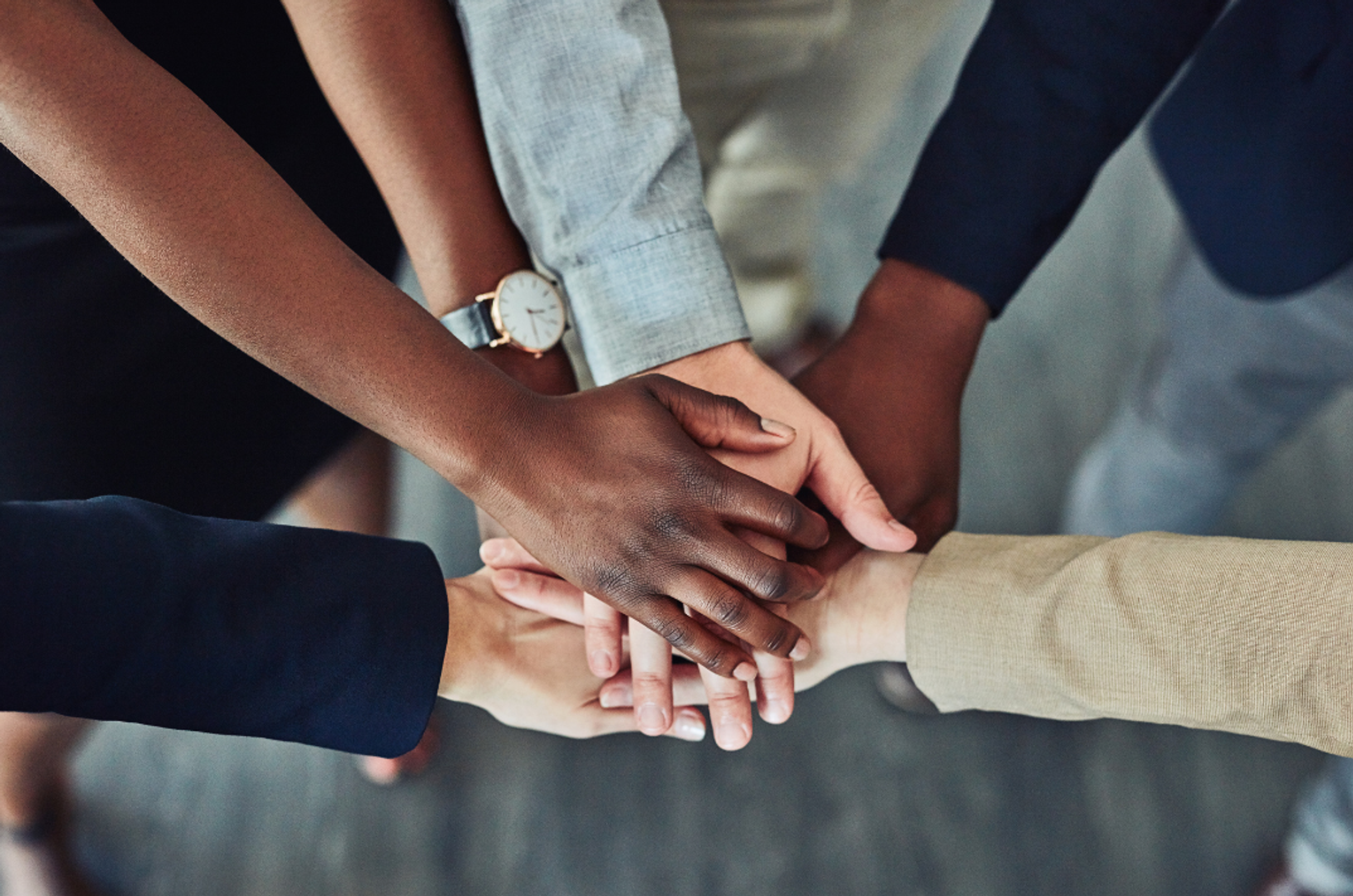 Hands joined together symbolizing team unity and shared commitment