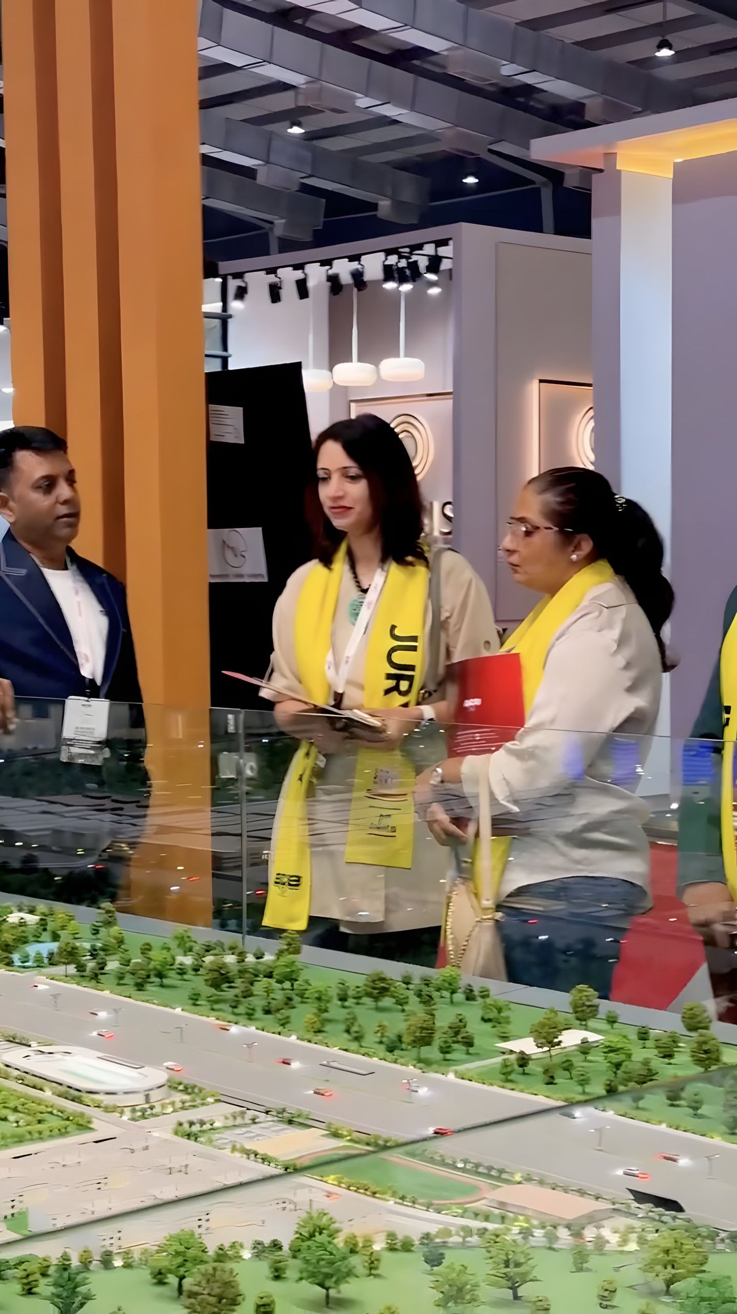 Visitors at the booth beside a model of the park