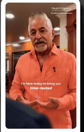 A creator in an orange shirt talking to camera in the barber shop: I’m here today to bring you time-tested