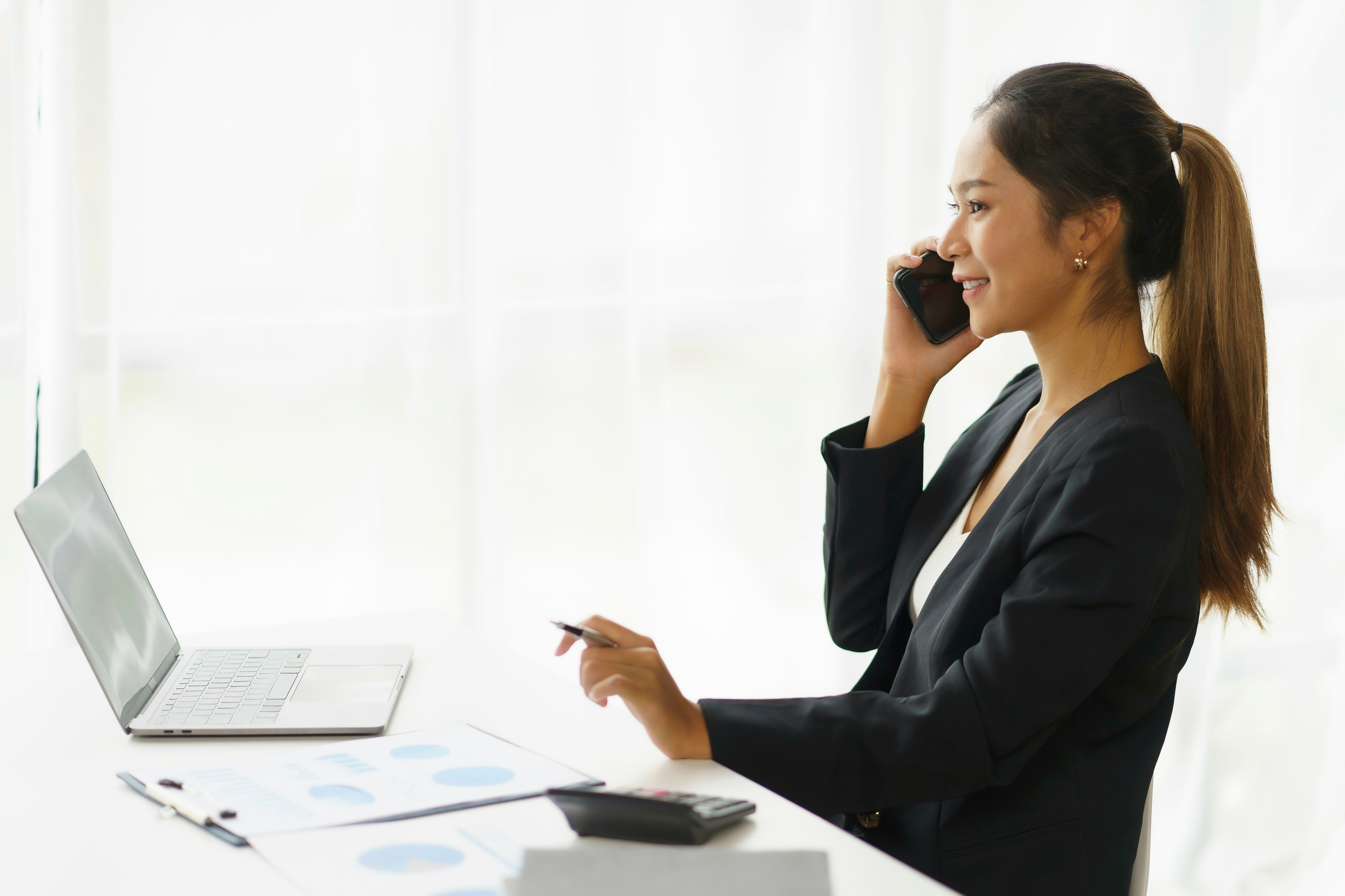 Account Executive au téléphone avec un prospect, devant son ordinateur