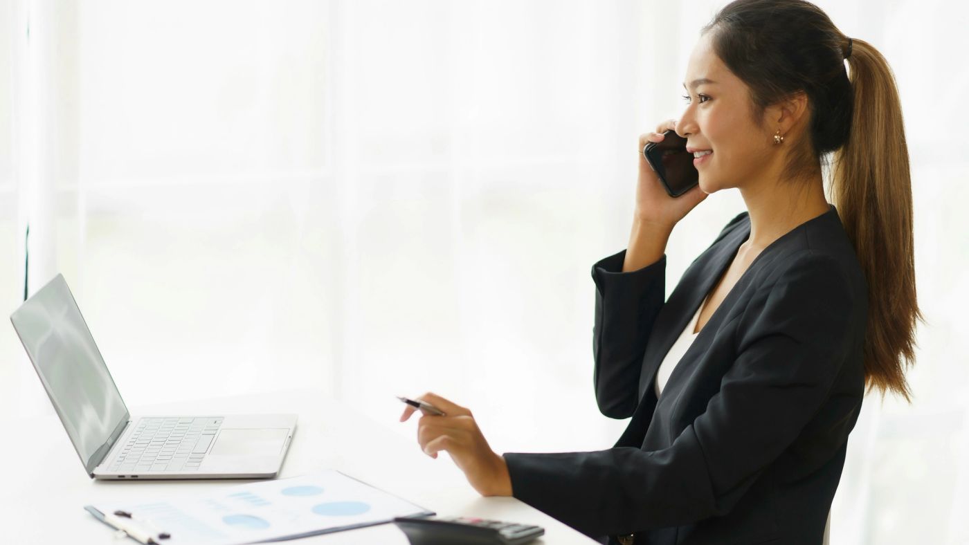 Account Executive au téléphone avec un prospect, devant son ordinateur