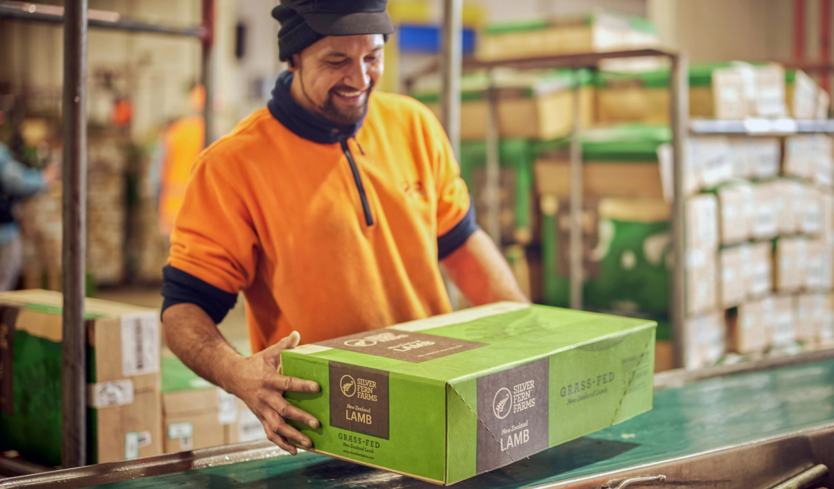 A warehouse worker holds box of Silver Fern Farms lamb