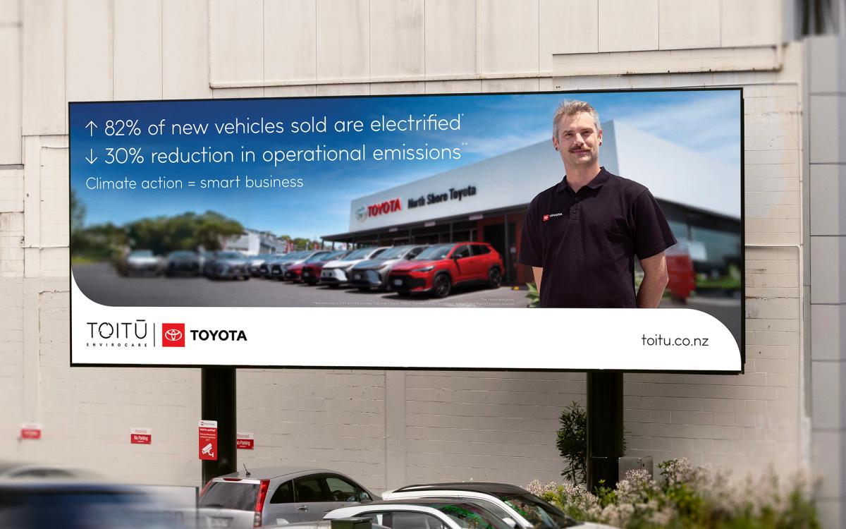 A photo of a HSE and Compliance Officer standing proudly in front of Toyota dealership