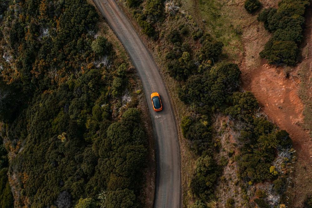 Te Toto Gorge Lookout, Raglan, New Zealand. Orange car Mini Cooper driving in Raglan towards Te Toto Gorge Lookout. Te Toto Gorge Lookout, Raglan, New Zealand. Orange car Mini Cooper driving in Raglan towards Te Toto Gorge Lookout.