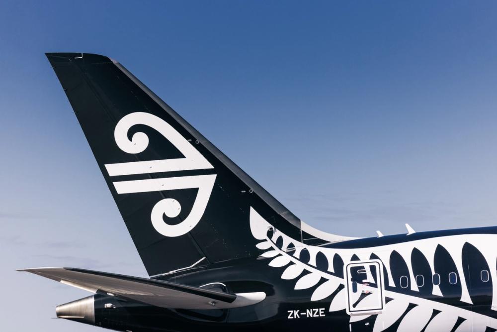A close up image of the tail of an Air New Zealand plane against a blue sky