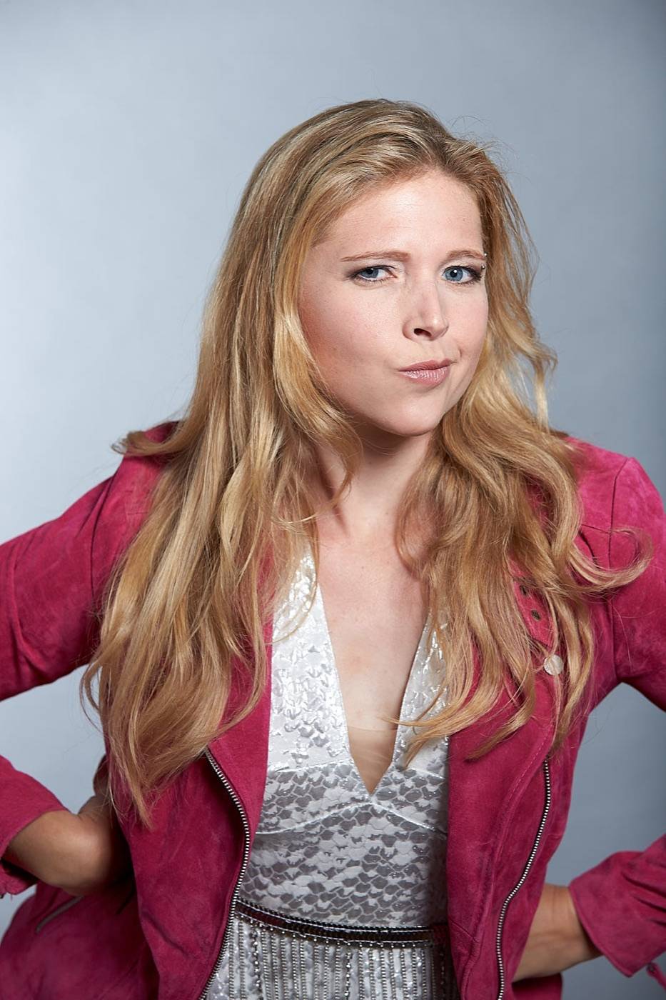Porträt von Nina Schromm in pinker Jacke, selbstbewusst in die Kamera blickend