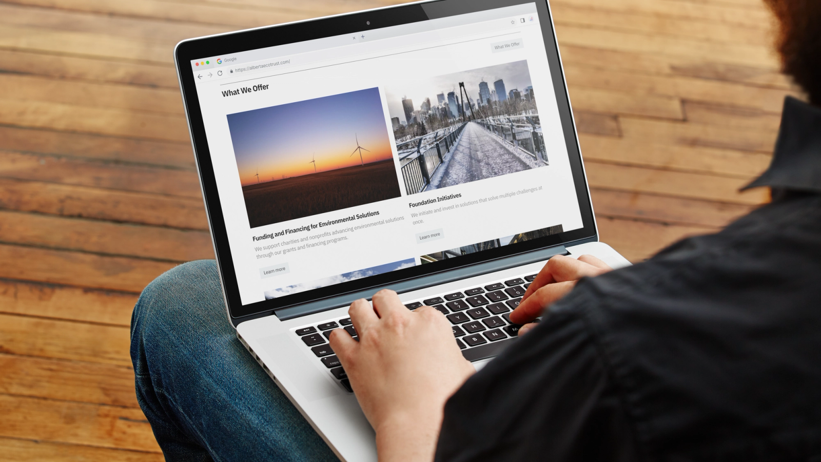 person using a computer scrolling through the Alberta Ecotrust homepage