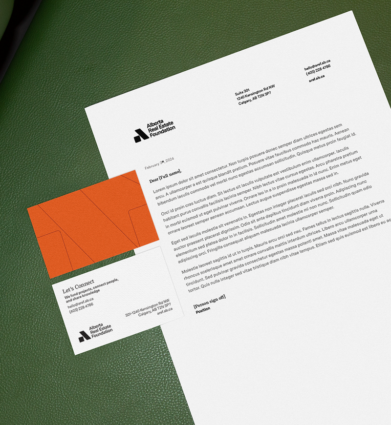 AREF letterhead template and a business card on a green leather sofa.