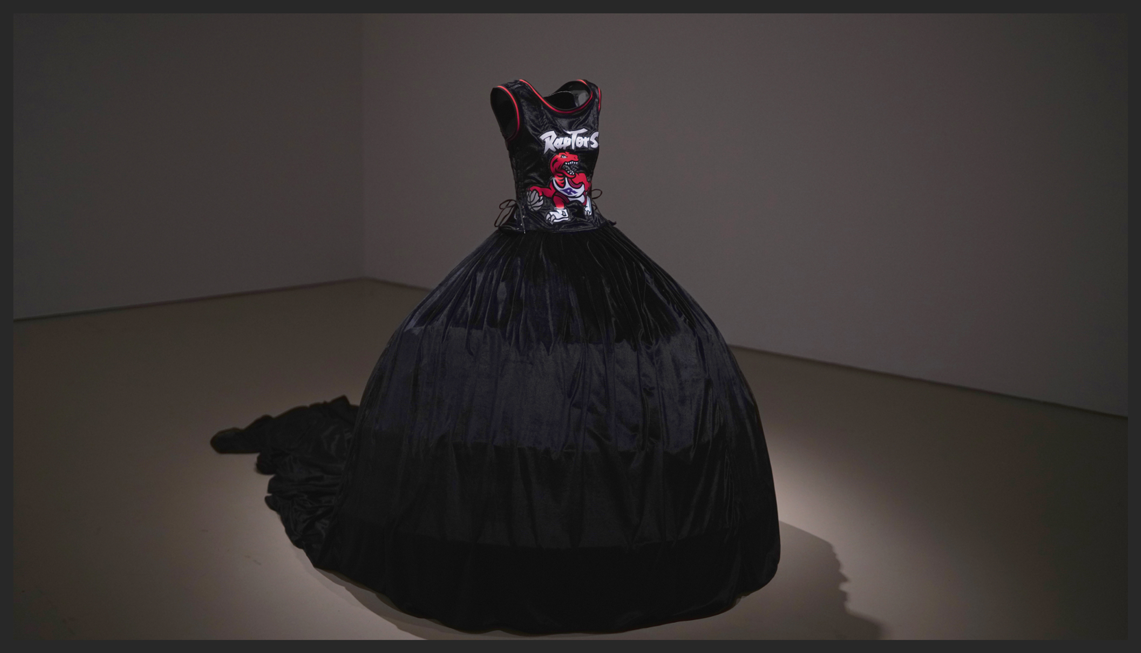 A sculpture of a black wearable dress made from a modified Raptor's jersey on the top and a velvet ballgown on the bottom
