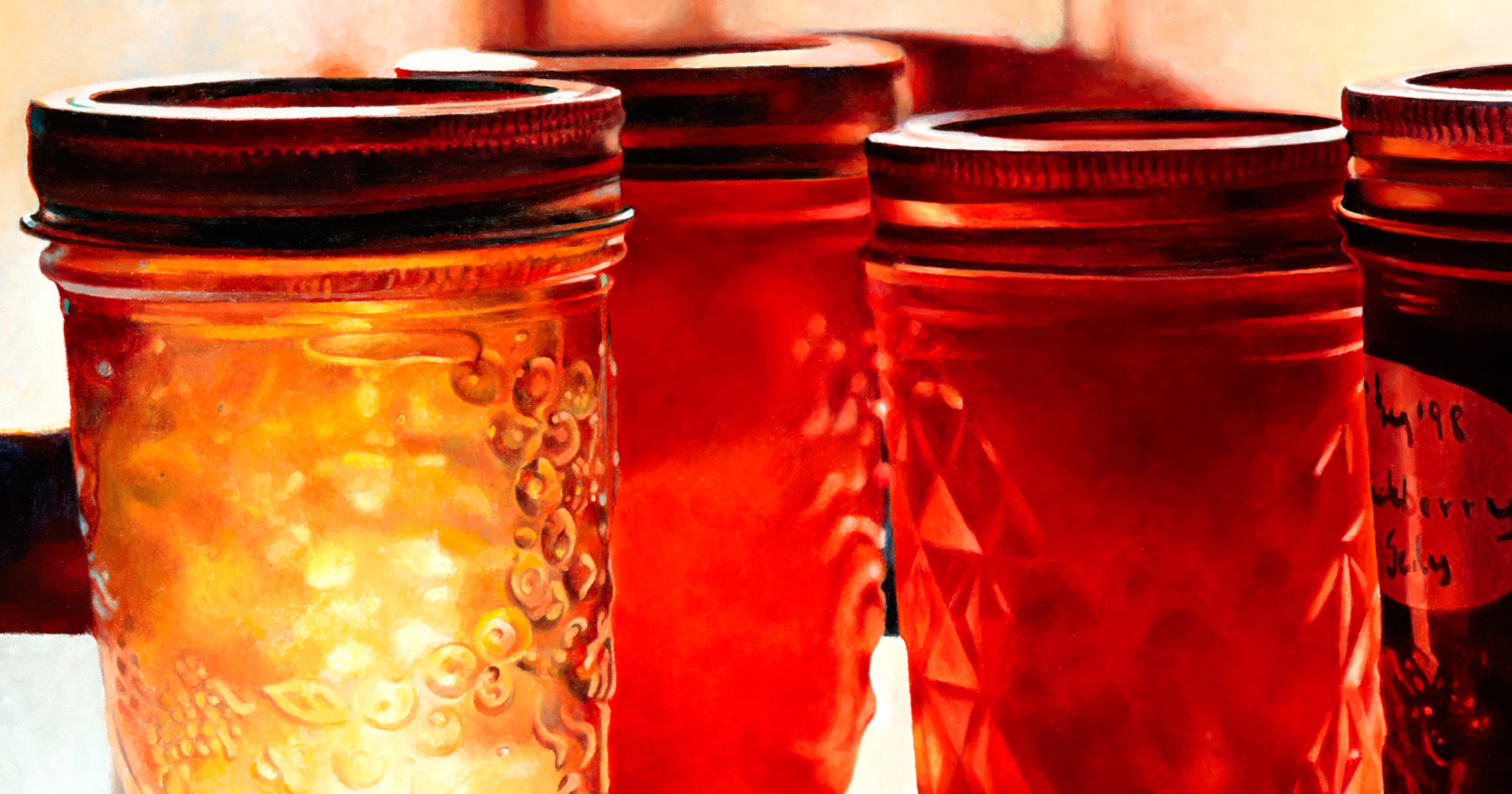 Four jars of coloured jellies sitting on a table with sunlight coming from behind.