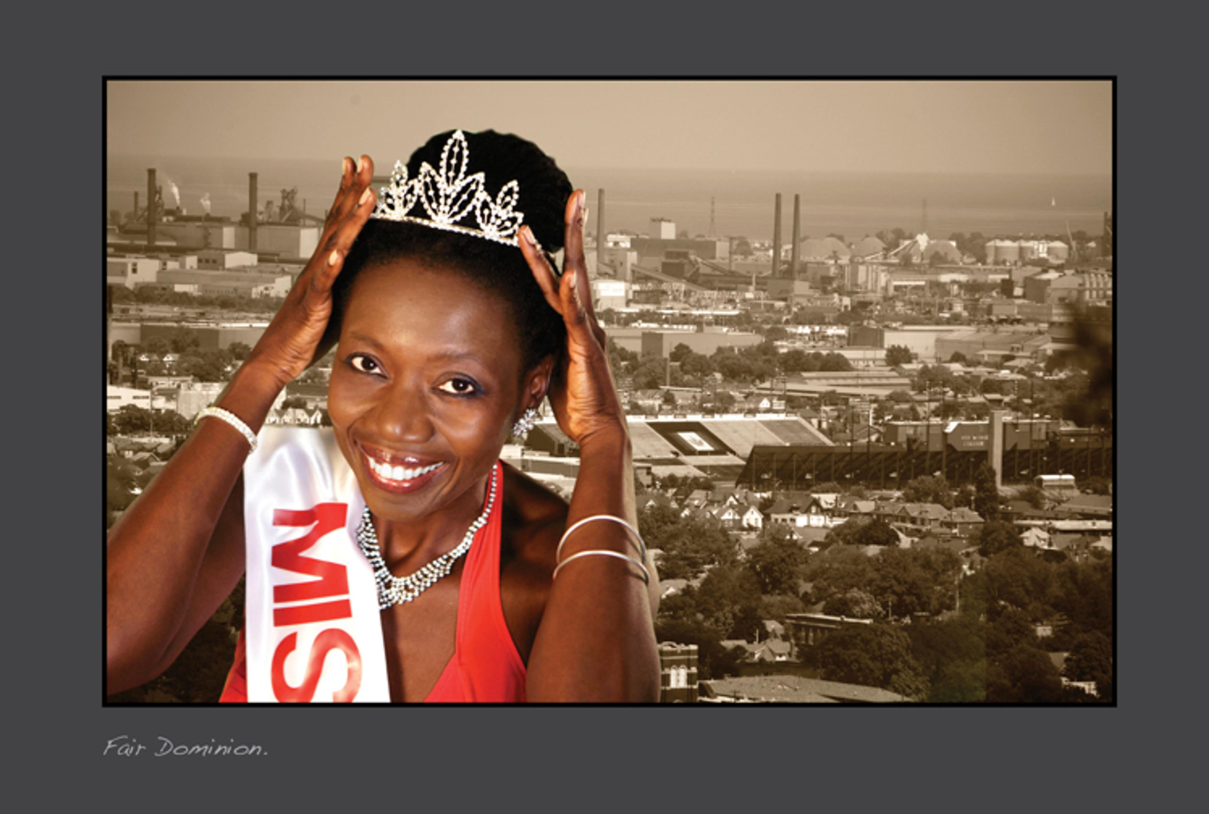The artist Camille Turner holds up her diamond crown with an industrial scene in the background.