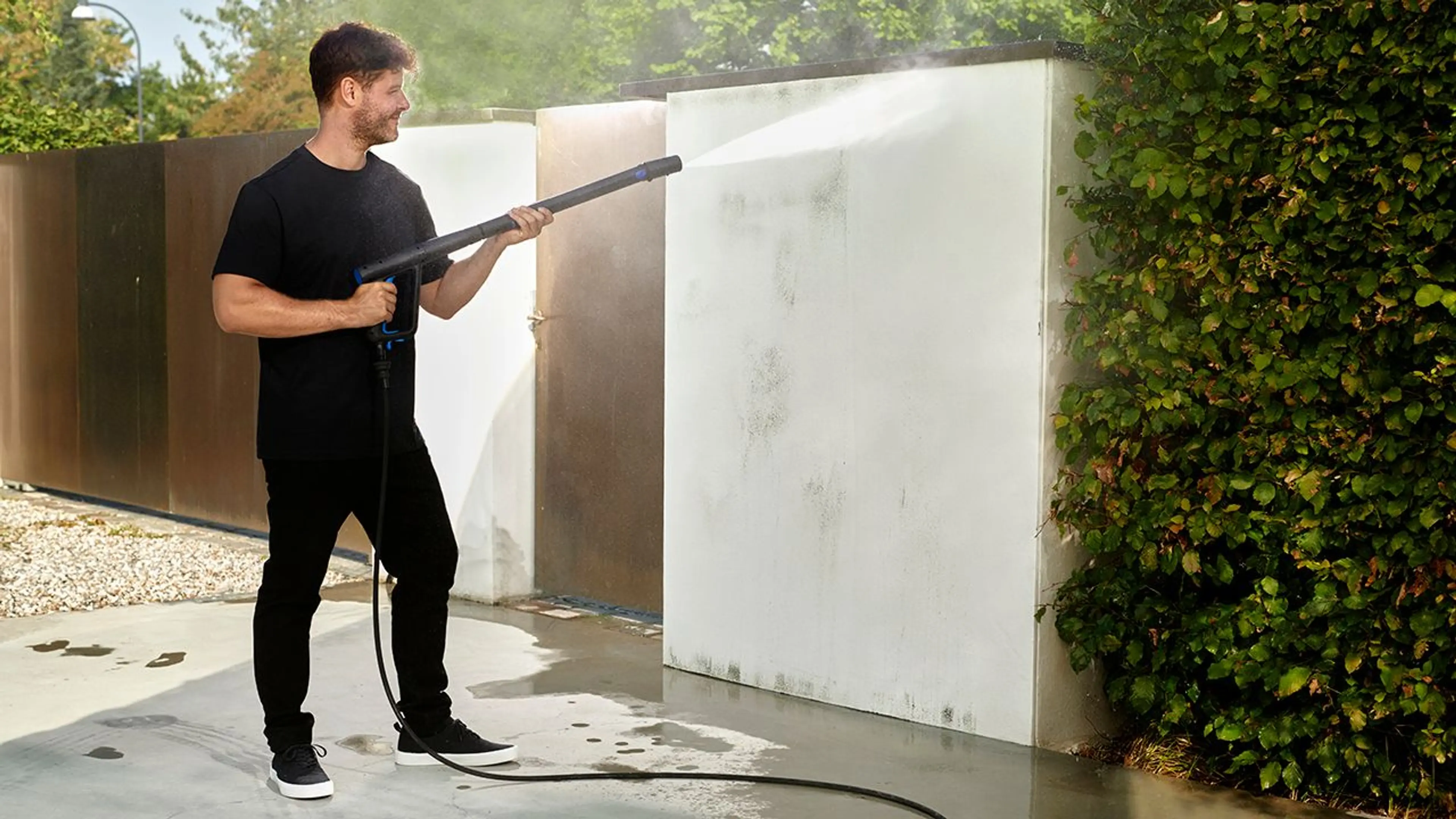 mann vasker en mur med høytrykksspyler