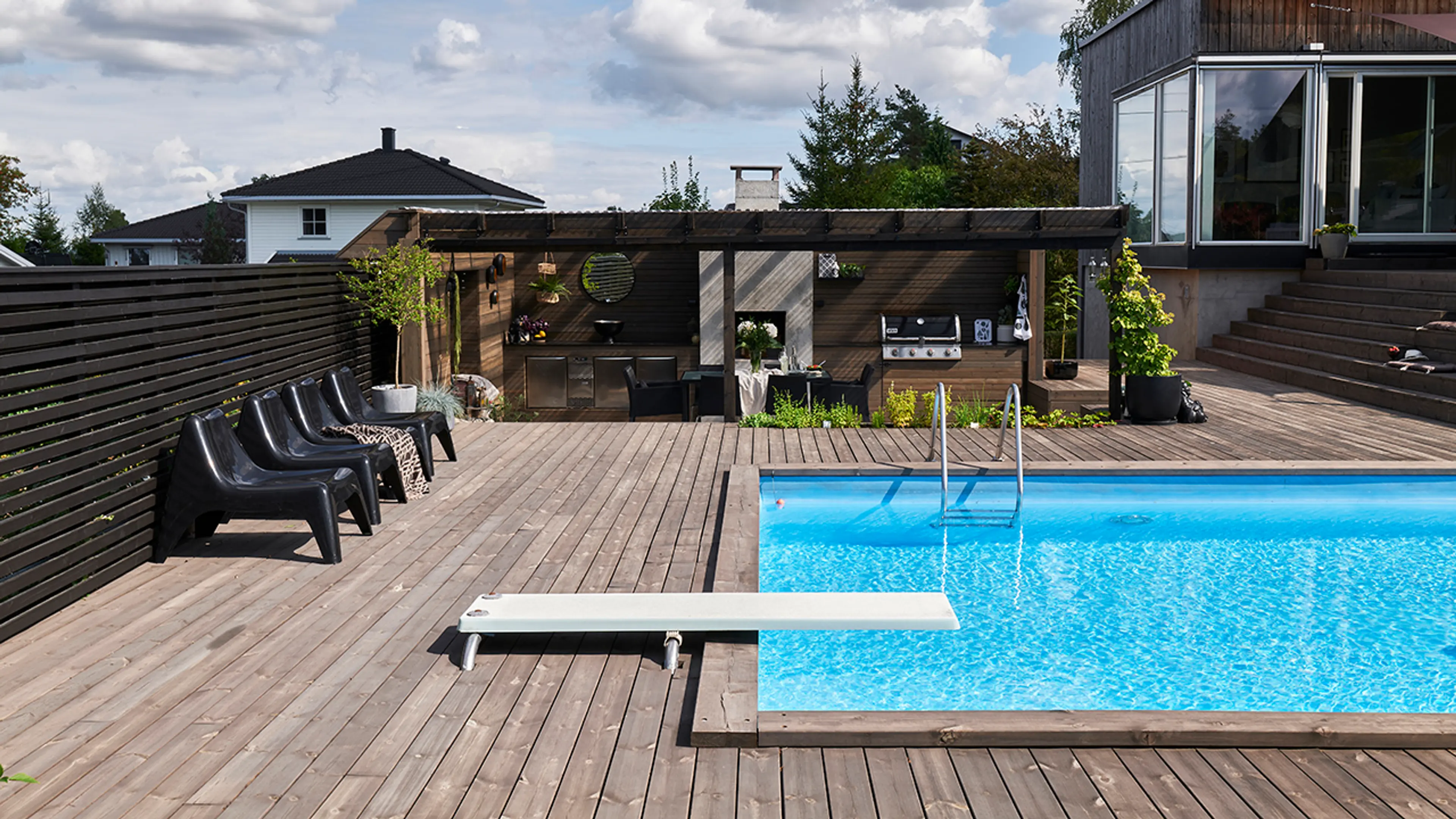 Terrasse med MøreRoyal terrassebord, pergola og svømmebasseng.