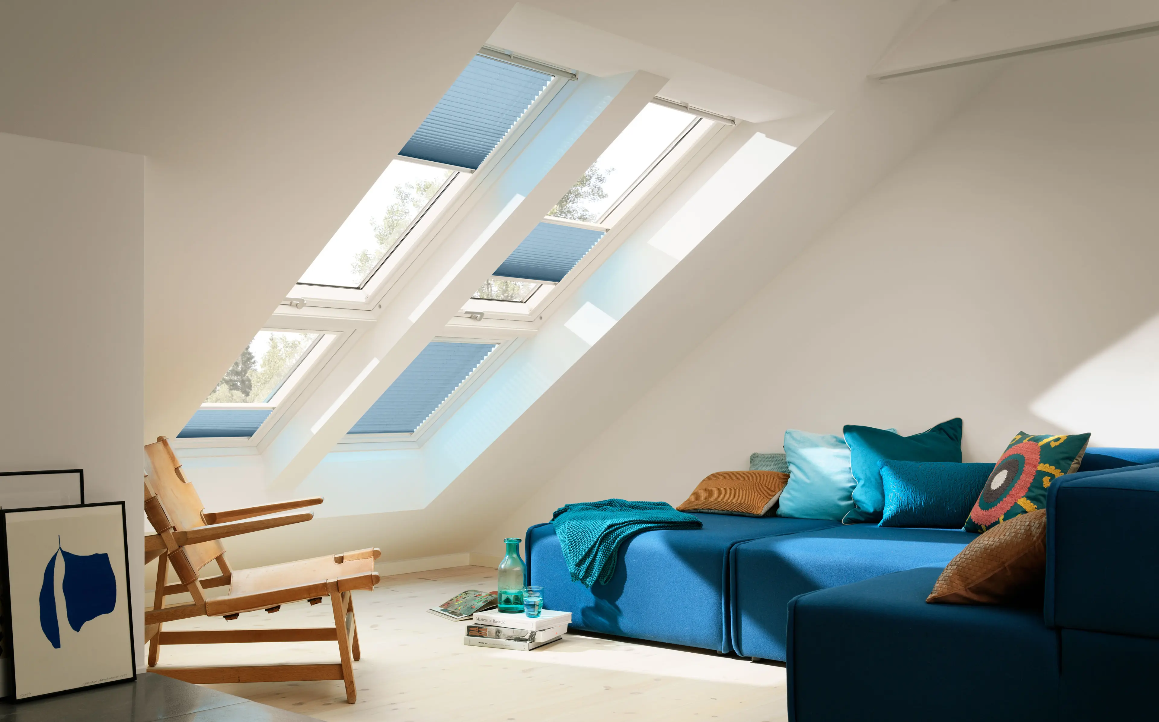 Blå sofa i rom med takvinduer