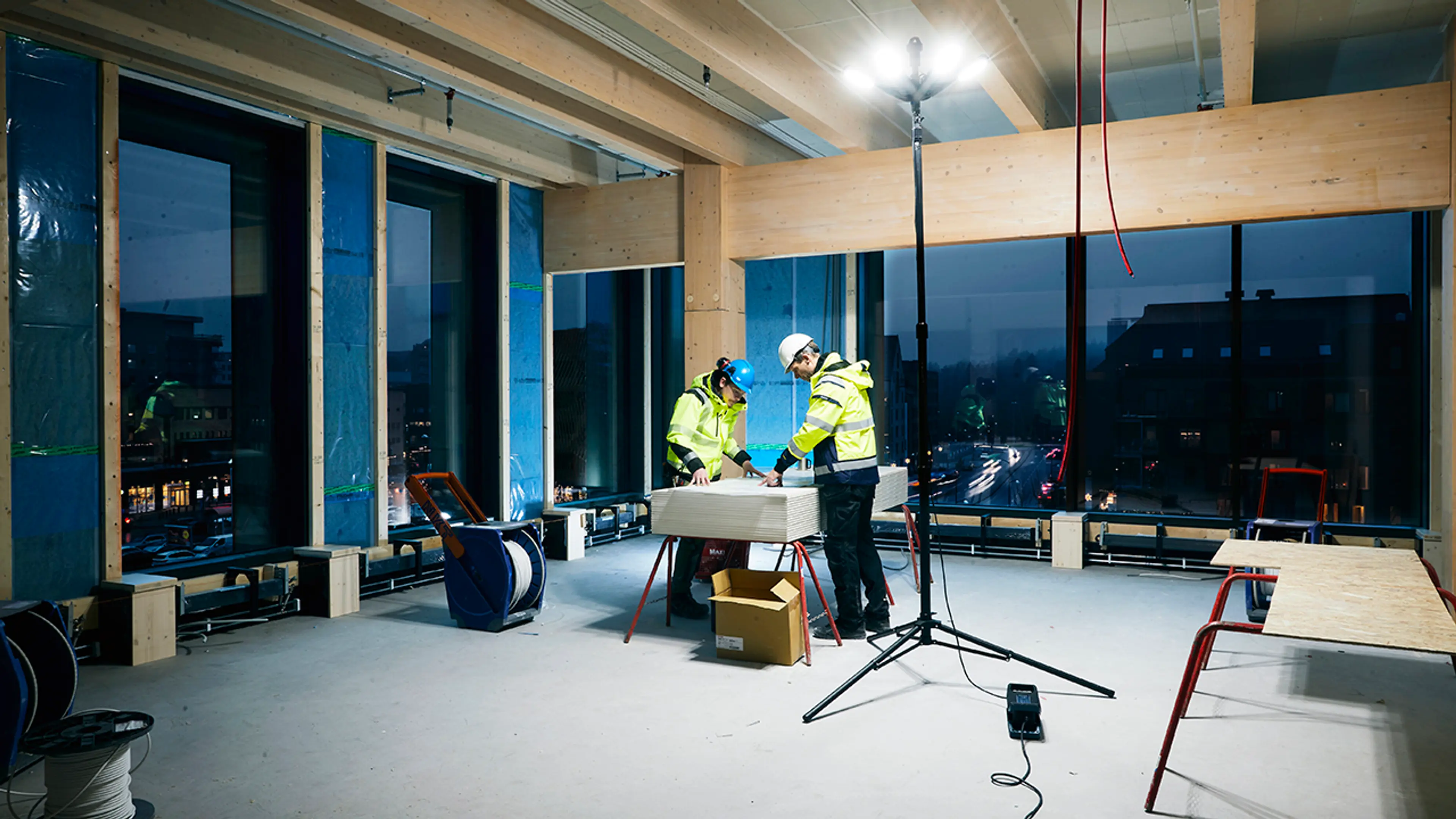 Håndverkere på byggeplass med arbeidslampe LED.