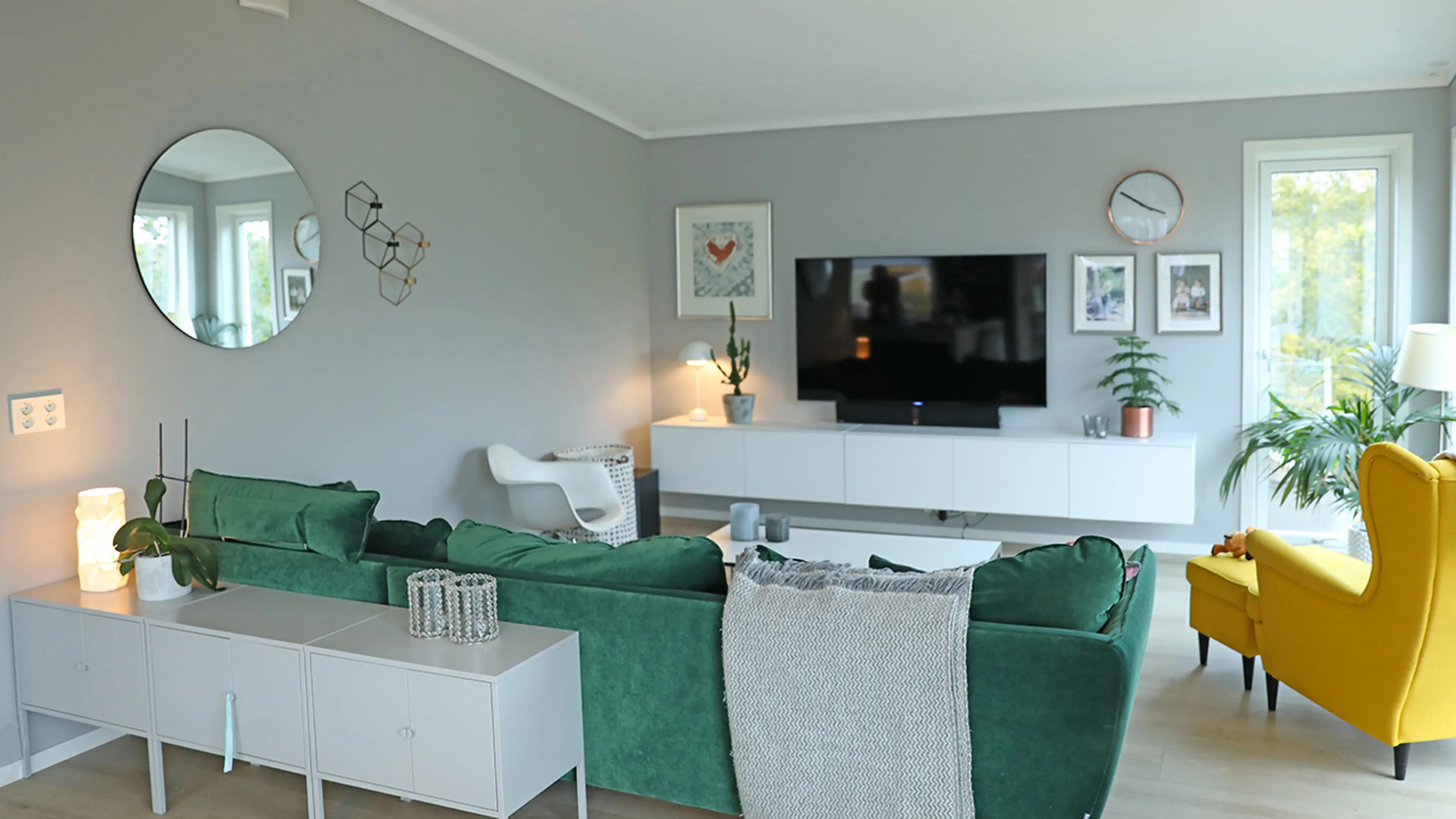 Lys stue med grønn sofa, gul lenestol og LaDura Premium gipsplater på veggene.