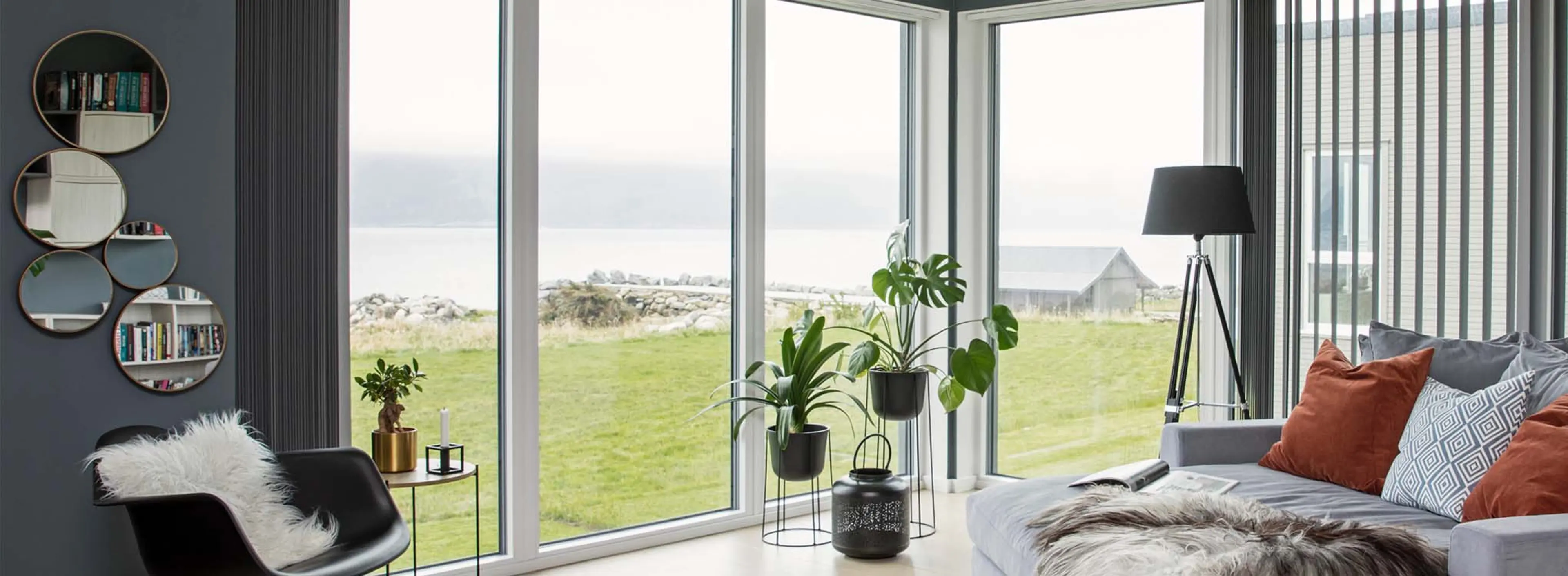 Store pvc-vinduer fra gulv til tak med utsikt mot havet. 
