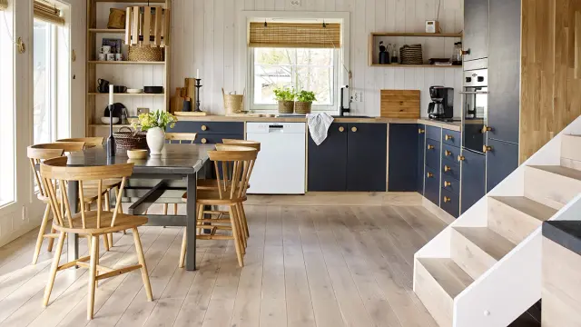 Kjøkken med heltre eikegulv og blå kjøkkeninnredning.