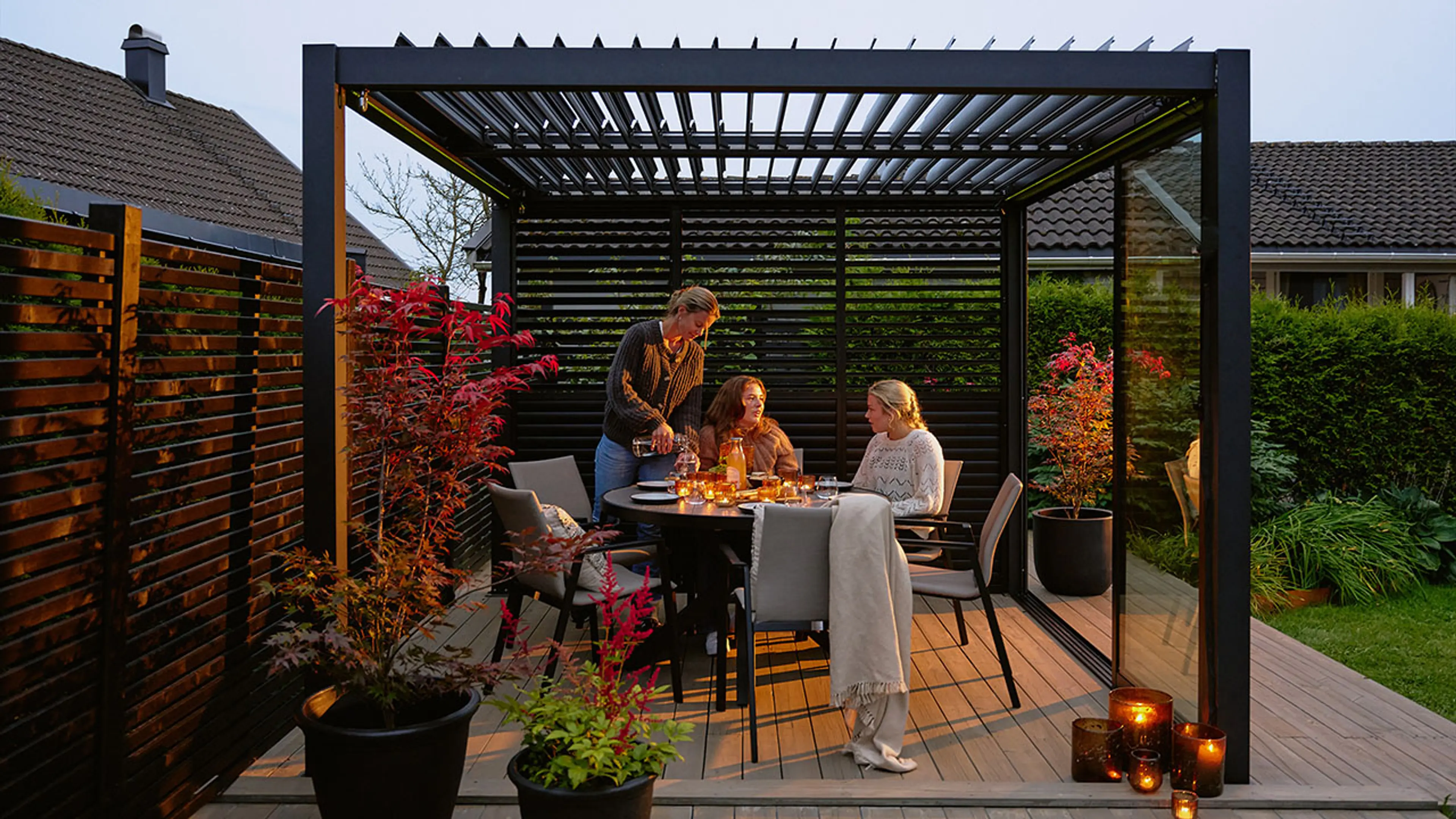 Frittstående terrasse med mørk moderne pergola.