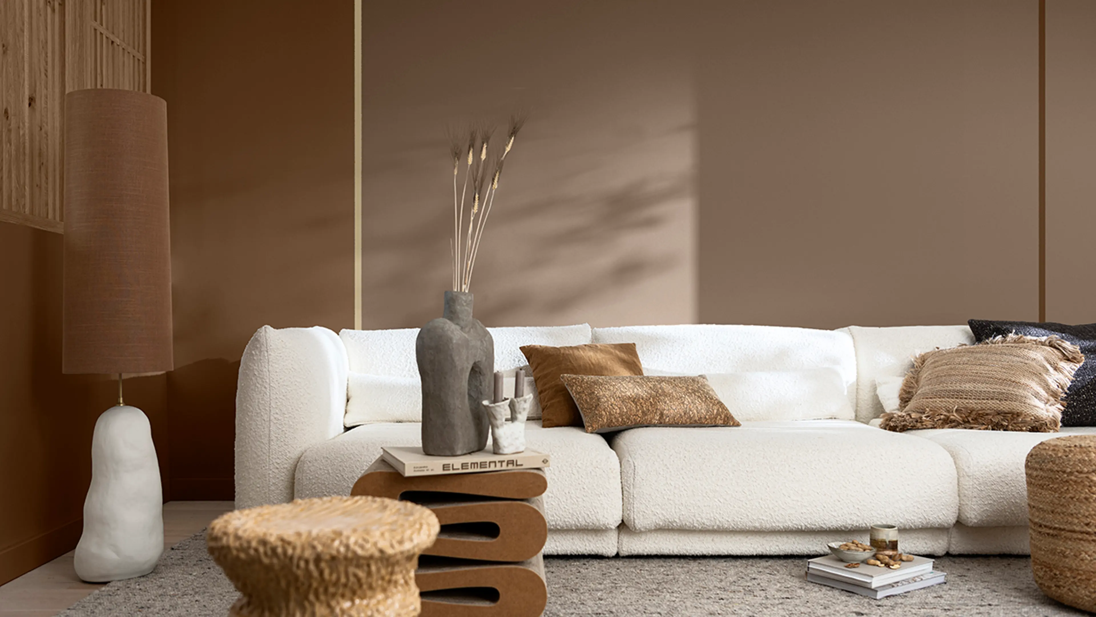 Stue med hvit sofa og vegger i forskjellige brune farger.