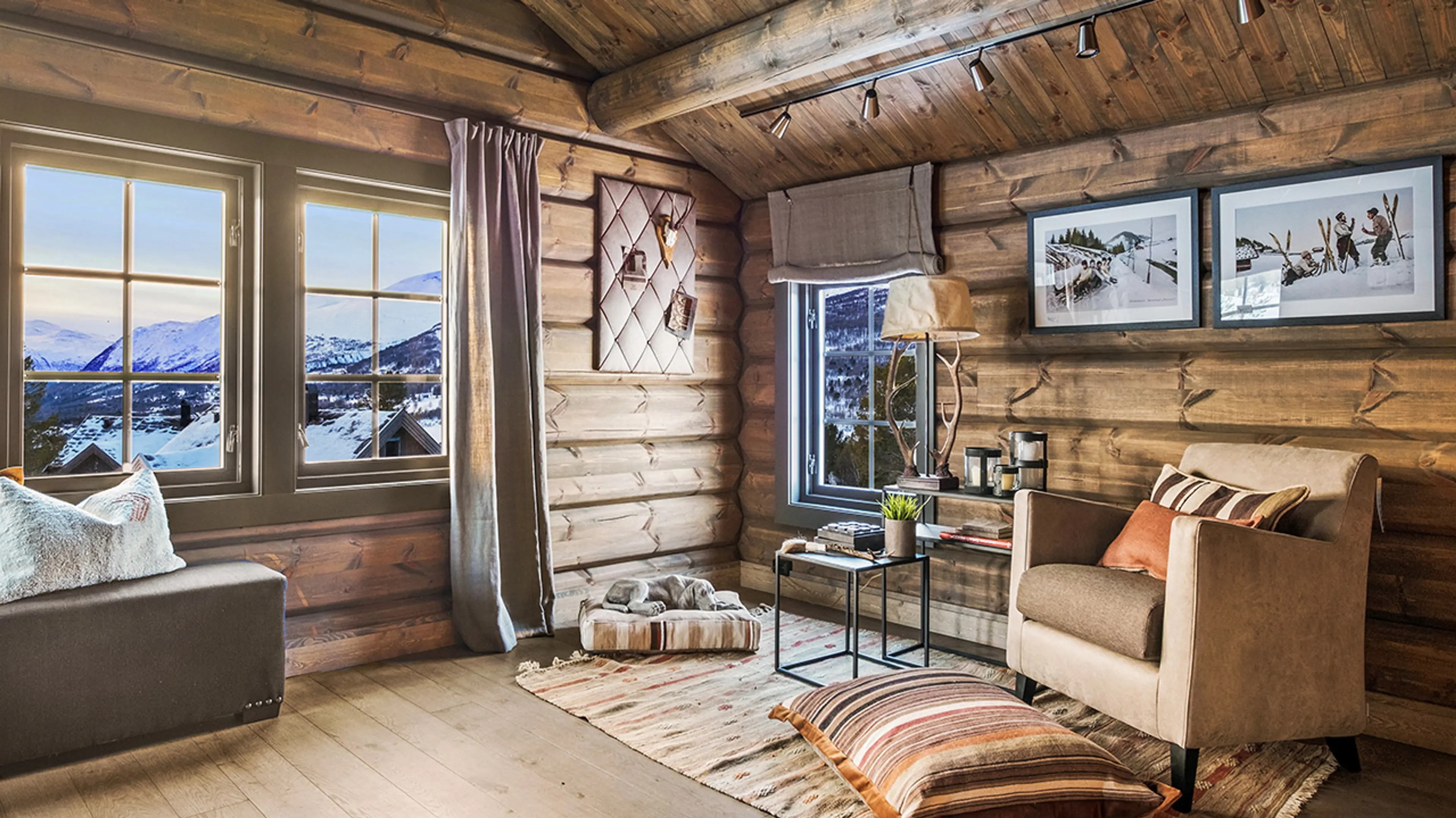 Rustikt hytteinteriør i laftet hytte med vinduer med sprosser.
