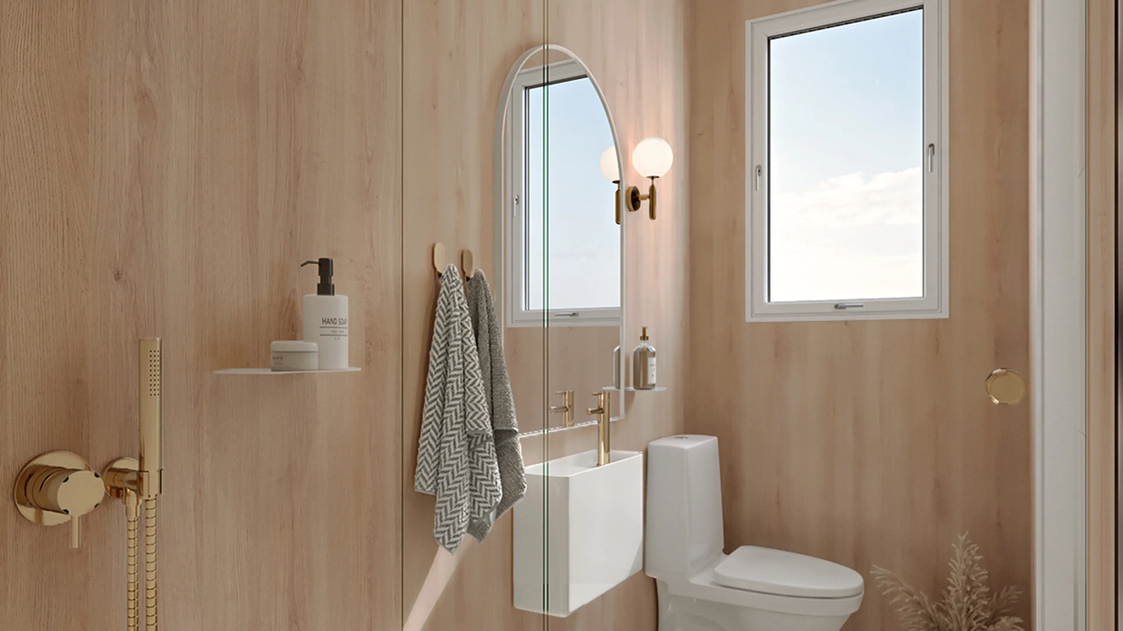 Hyttebad med veggplater i lys eik, hvite baderomsmøbel og gylne detaljer i messing.